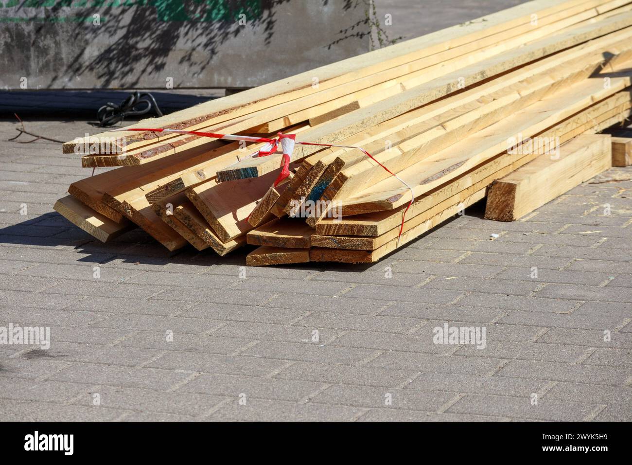 Materiale da costruzione in legno su asfalto in una strada cittadina Foto Stock