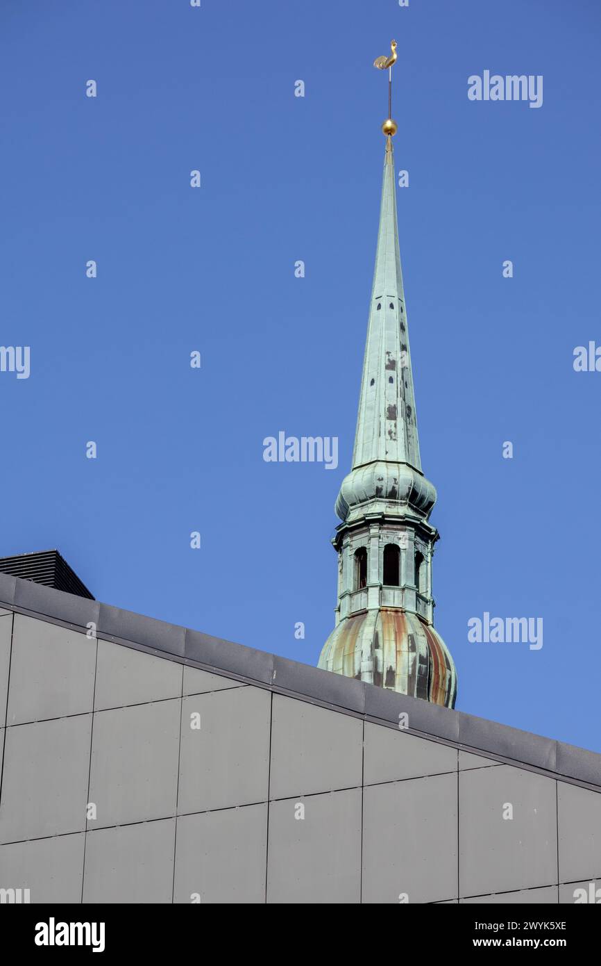 Un'alta torre della chiesa con un gallo dorato in cima alla torre Foto Stock