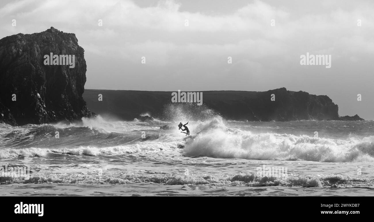 Wave board surf in enormi breakers, Kynance Cove, Cornovaglia. Spazzare via a forma di simbolo Manx. O Triskel o Triskelion. Affrontare le onde Foto Stock