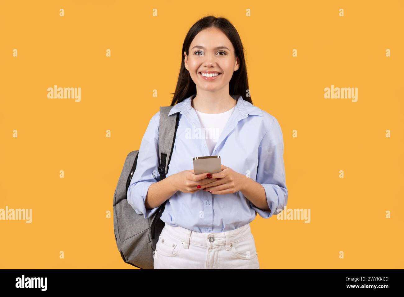 Giovane donna con telefono che sembra piacevolmente sorpresa Foto Stock