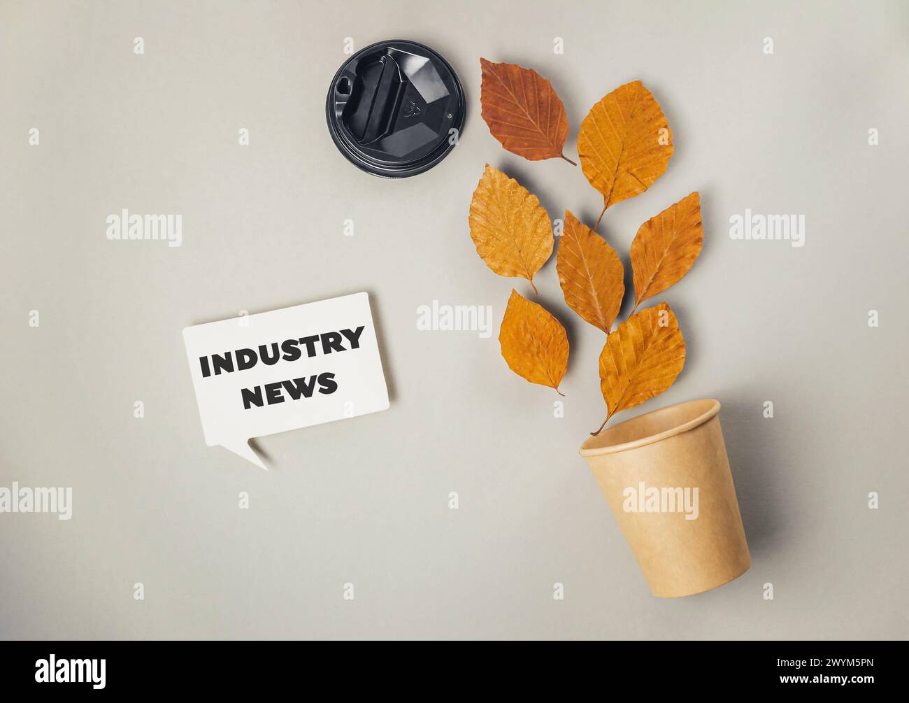 Un segno che dice Industry News è su uno sfondo grigio. C'è una pianta in vaso con delle foglie Foto Stock