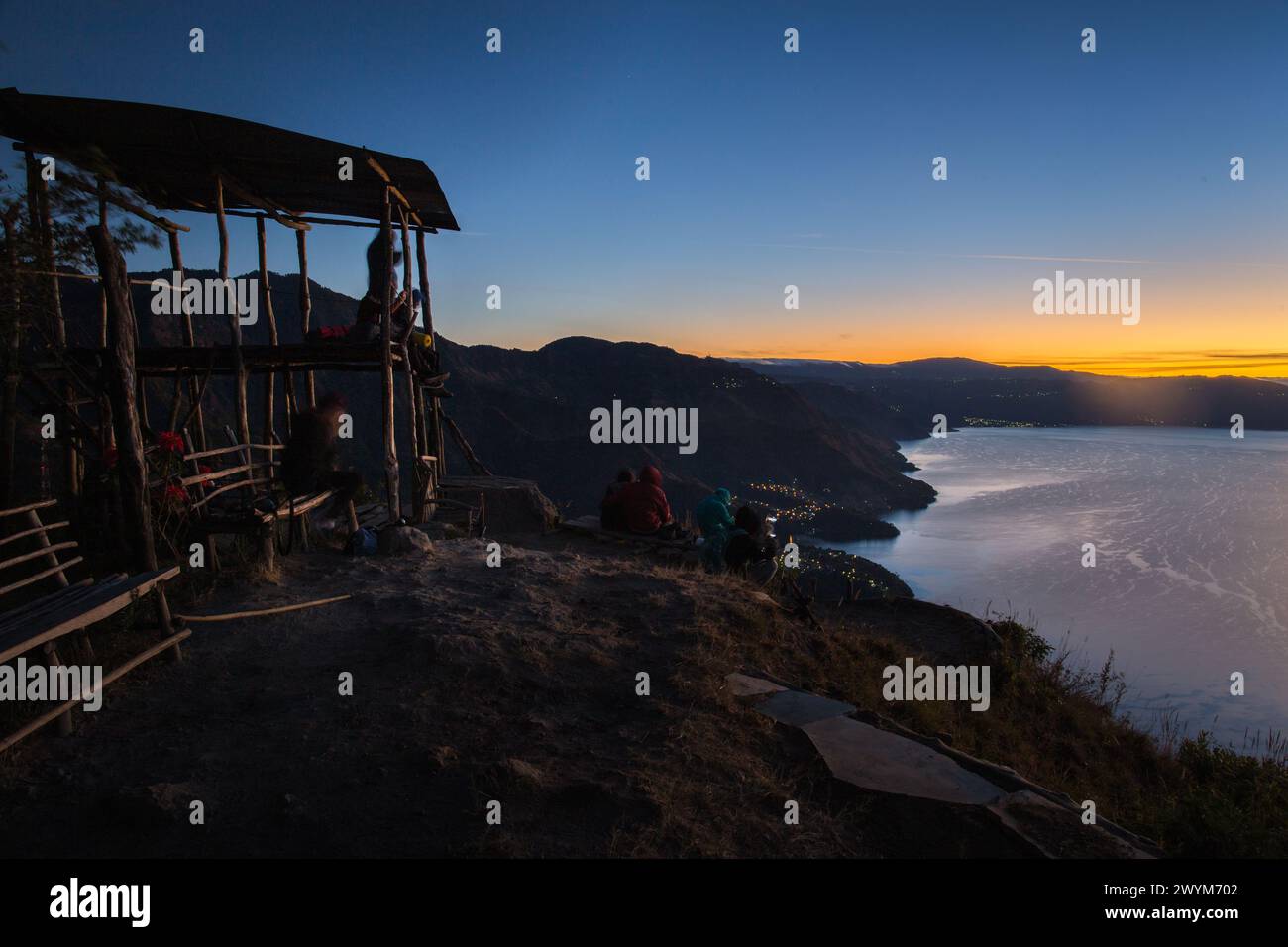 Le persone si siedono e aspettano l'alba al punto panoramico e la torre di osservazione a Maya Nose nel lago Atitlan in Guatemala Foto Stock