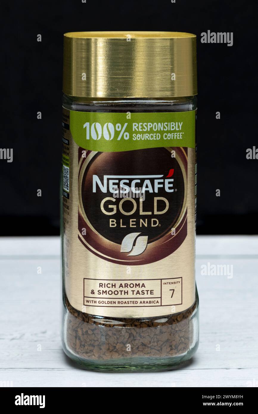 Irvine, Scozia, Regno Unito - 26 marzo 2024: Barattolo di caffè Nescafe Gold in un vaso di vetro completamente riciclabile e parte superiore in plastica con grafica e icona Foto Stock