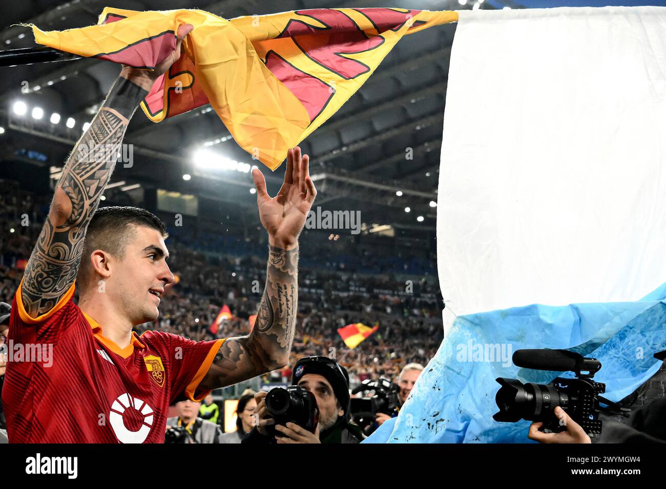 Gianluca Mancini di AS Roma celebra la vittoria sventolando una bandiera laziale con un topo raffigurato al termine della partita di serie A tra AS Roma e SS Lazio allo stadio Olimpico di Roma (Italia), 6 aprile 2024. Foto Stock