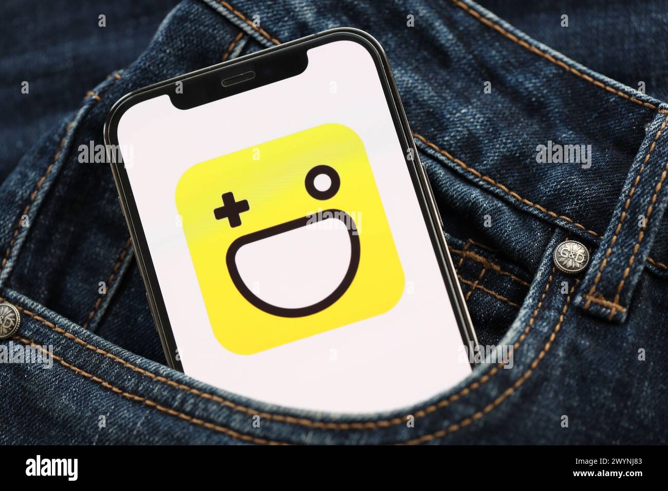 KIEV, UCRAINA - 1 APRILE 2024 icona Hago sullo schermo dello smartphone nella tasca dei jeans. Il display iPhone con il logo dell'app si nasconde in un'elegante tascabile Foto Stock