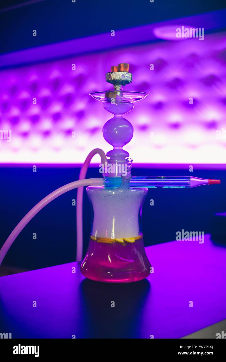 Narghilè in vetro con ciotola e carbone con frutta per il tradizionale relax orientale. Messa a fuoco morbida Foto Stock