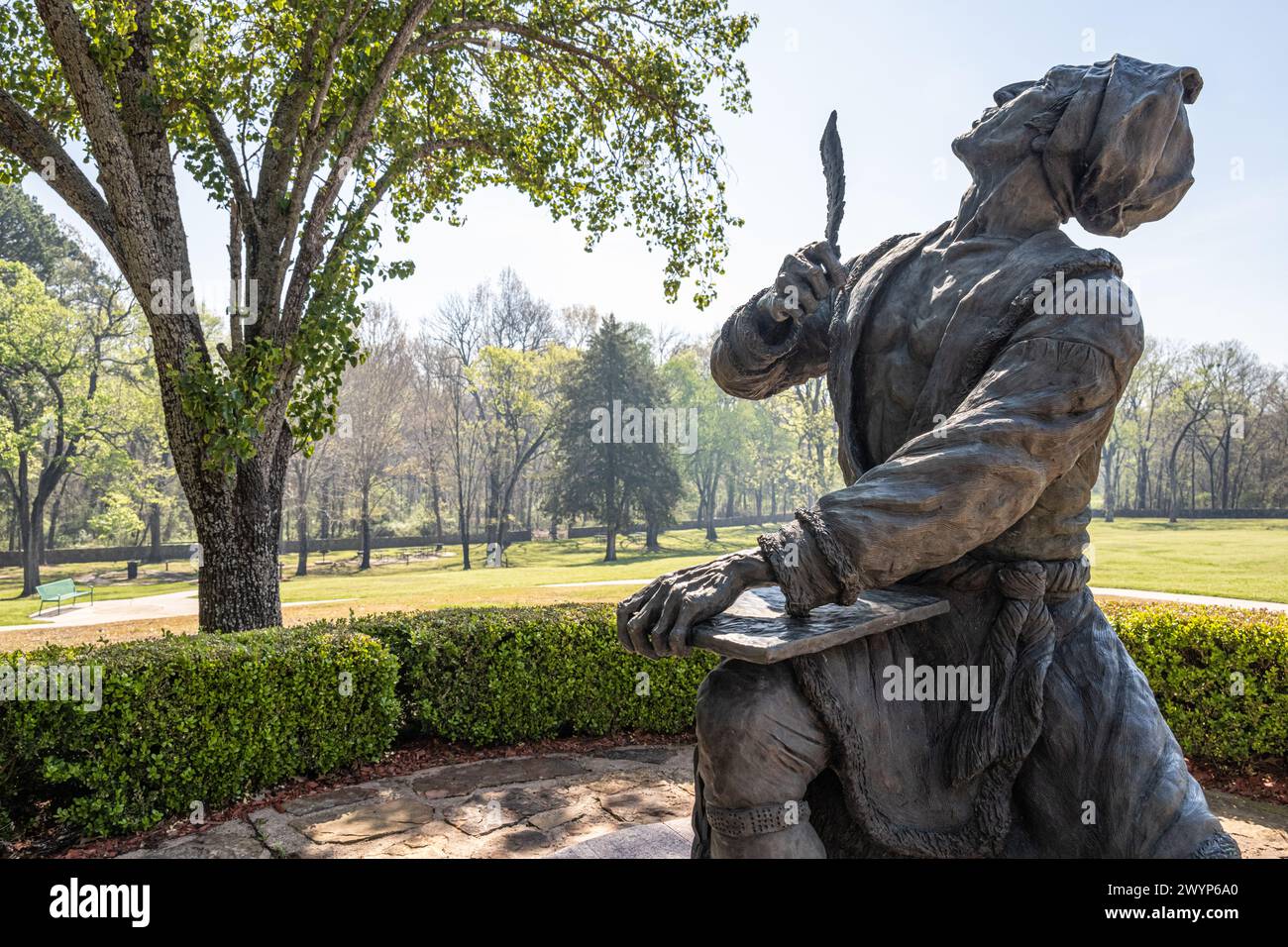Statua dell'inventore Cherokee dell'alfabeto indiano Sequoyah, che guarda verso l'alto con penna di quill piuma, presso il sito storico Sequoyah's Cabin a Sallisaw, Oklahoma. (USA) Foto Stock