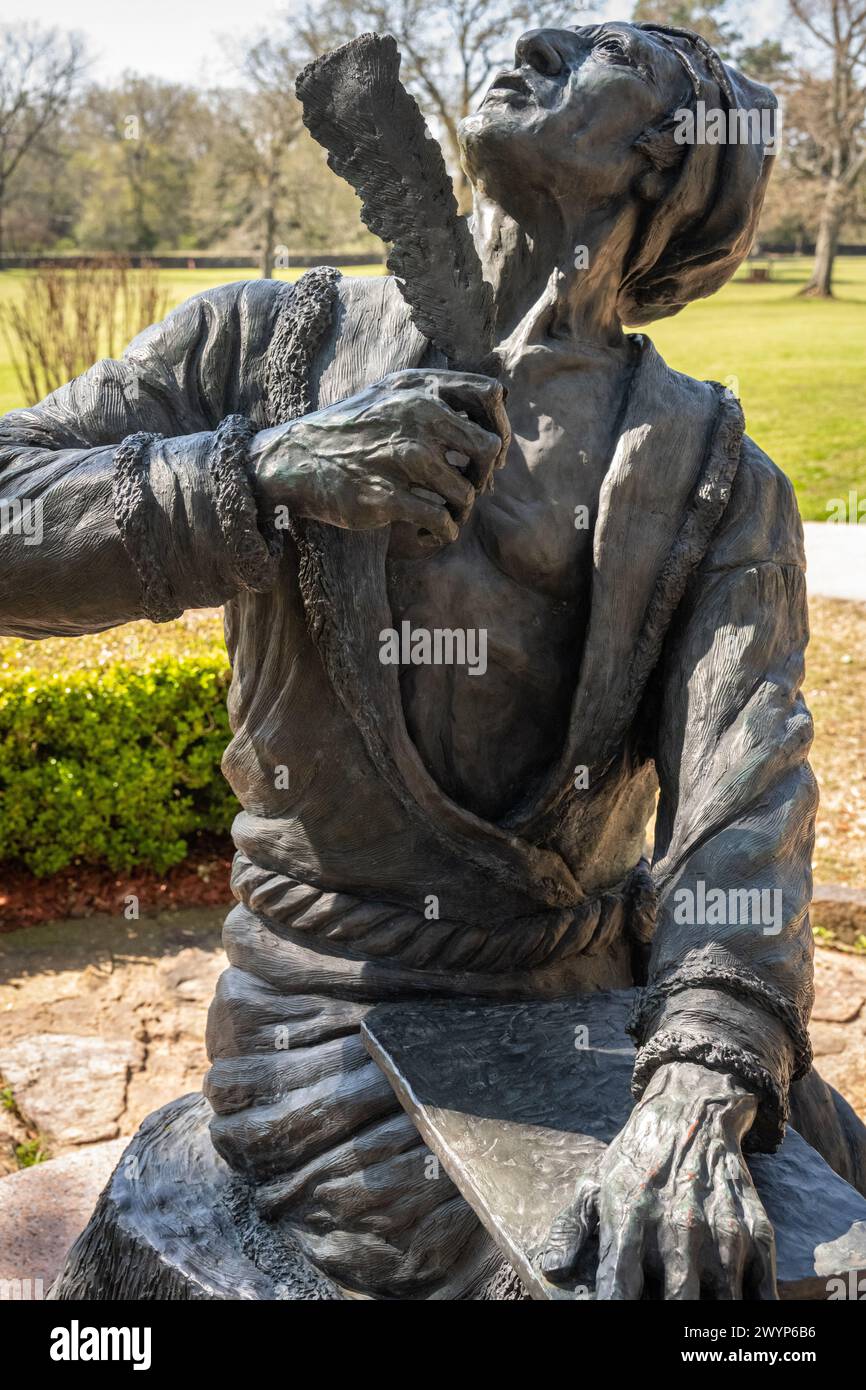 Statua dell'inventore Cherokee dell'alfabeto indiano Sequoyah, che guarda verso l'alto con penna di quill piuma, presso il sito storico Sequoyah's Cabin a Sallisaw, Oklahoma. (USA) Foto Stock