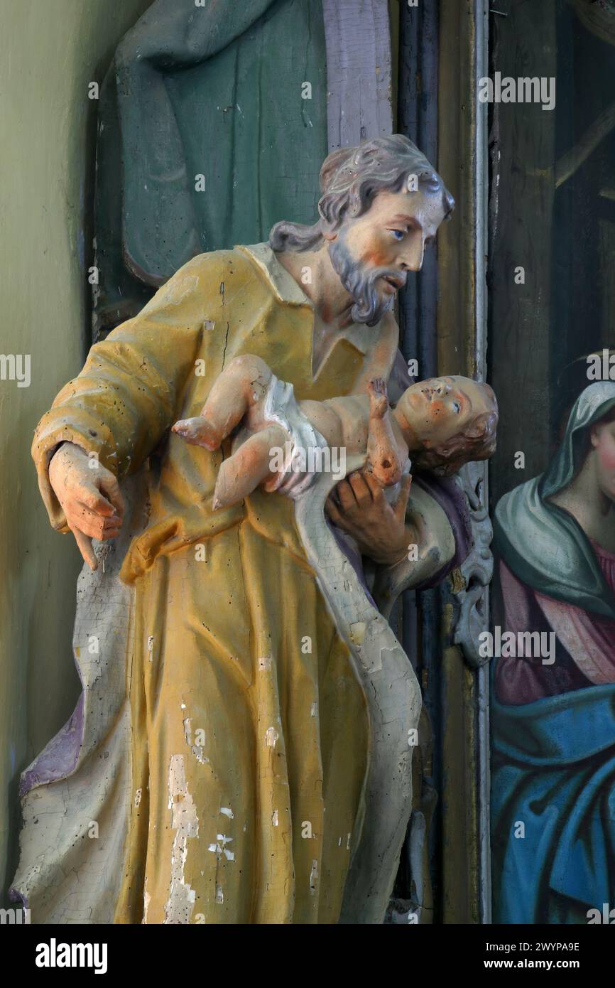San Giuseppe che tiene il bambino Gesù, statua sull'altare dei Santi tre Re nella chiesa parrocchiale di San Martino a Pisarovinska Jamnica, Croati Foto Stock