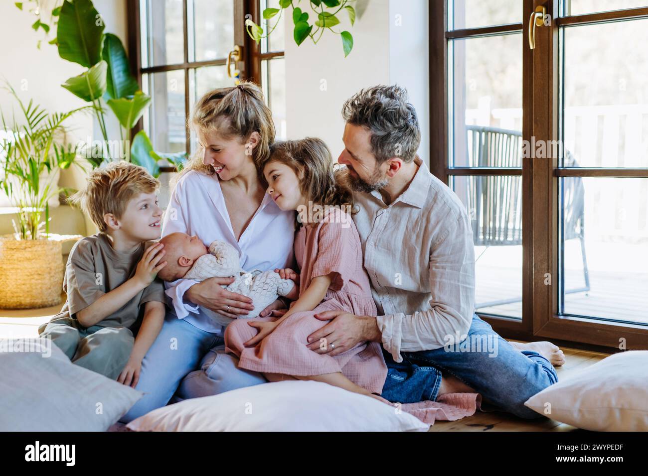 Ritratto di famiglia nucleare con neonato. Momento perfetto. Famiglia forte, legame, amore incondizionato dei genitori per i loro figli. Foto Stock
