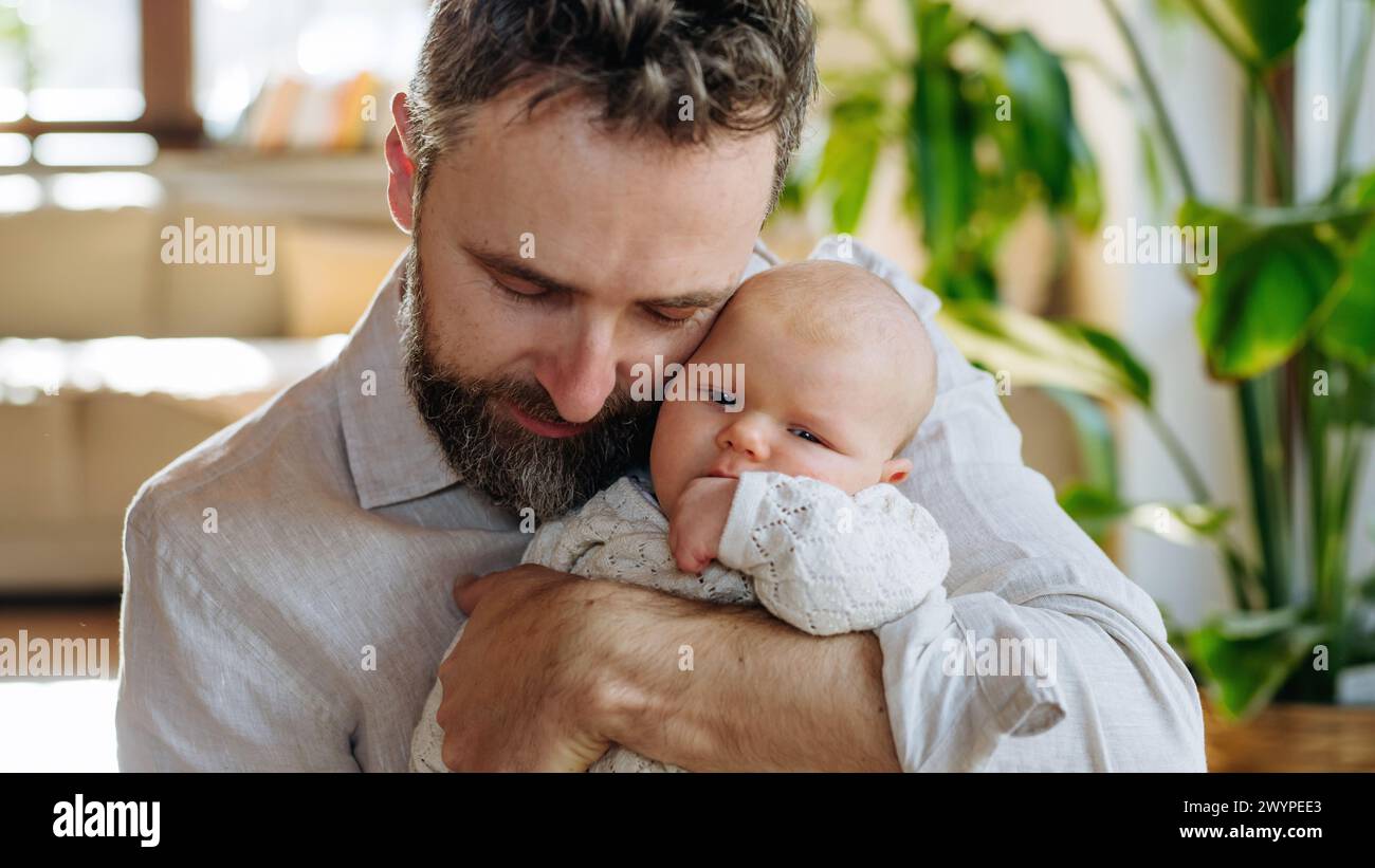 Padre che tiene in braccio il suo bambino appena nato. Amore paterno incondizionato, concetto di festa del papà. Foto Stock