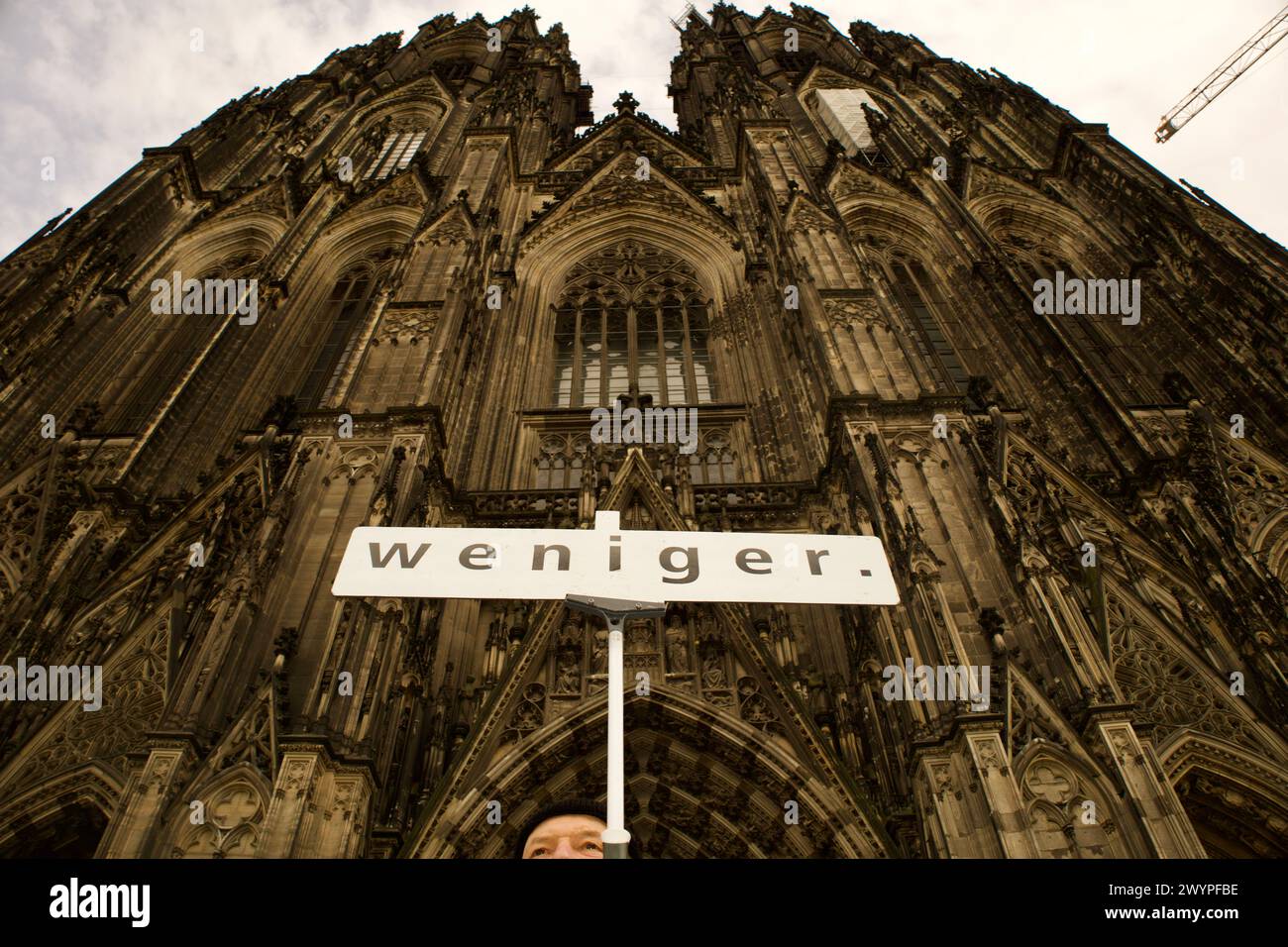 Colonia, Germania, 7 aprile 2024 - un uomo si trova di fronte alla Cupola di Colonia con un cartello con la scritta "WENIGER", che è il suo cognome, il suo dominio Foto Stock