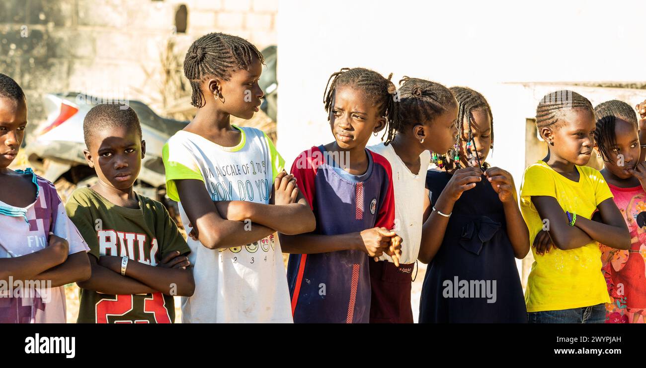 MBOUR, SENEGAL - CIRCA MARZO 2021. Gruppo non identificato di bambini africani poveri e adolescenti che giocano all'aperto Foto Stock