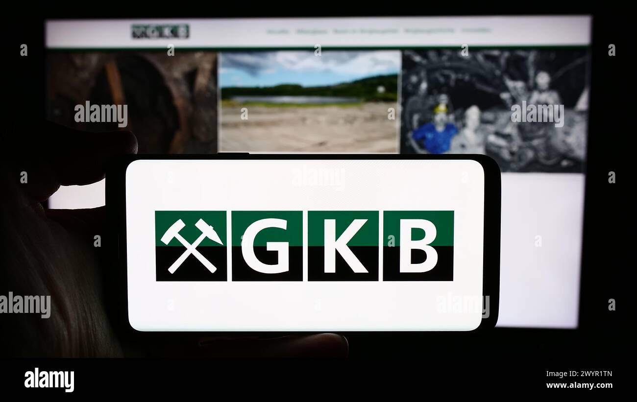 Persona con smartphone con logo della società austriaca GKB Bergbau GmbH davanti al sito web. Mettere a fuoco il display del telefono. Foto Stock