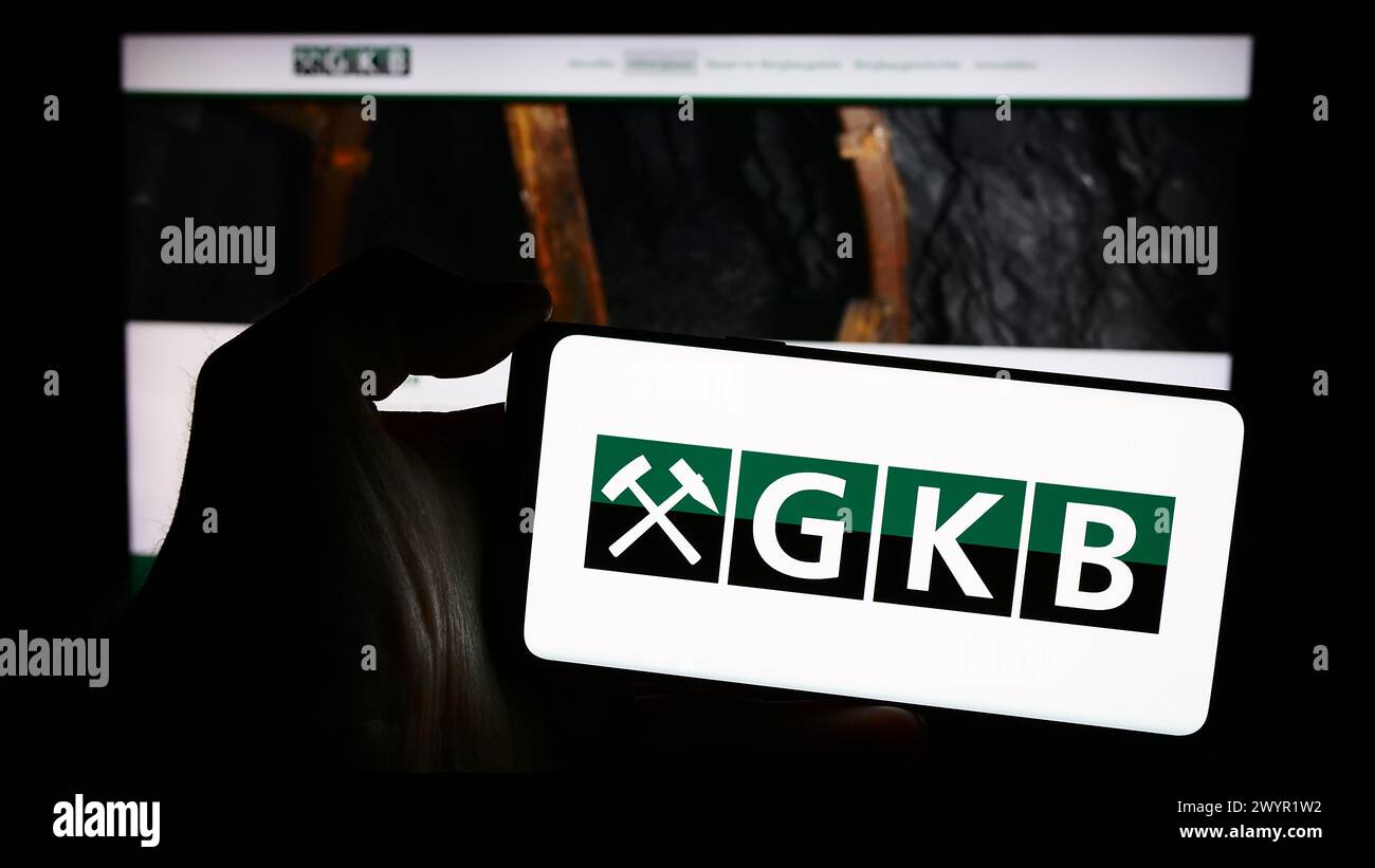 Persona che possiede un telefono cellulare con il logo della società austriaca GKB Bergbau GmbH davanti alla pagina web. Mettere a fuoco il display del telefono. Foto Stock