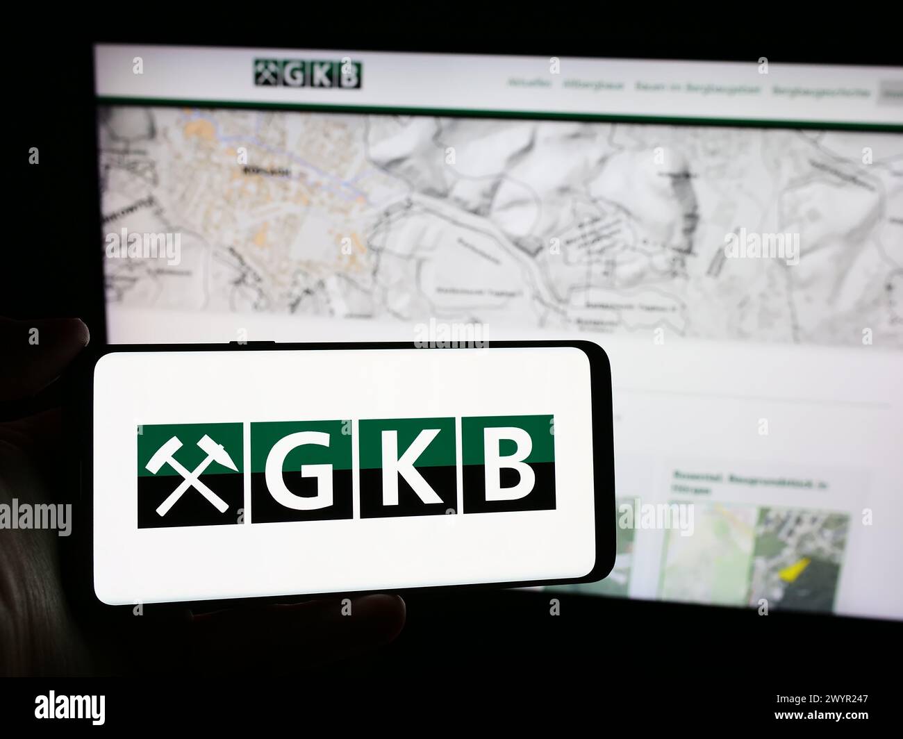 Persona che detiene un cellulare con il logo della società austriaca GKB Bergbau GmbH davanti alla pagina web. Mettere a fuoco il display del telefono. Foto Stock