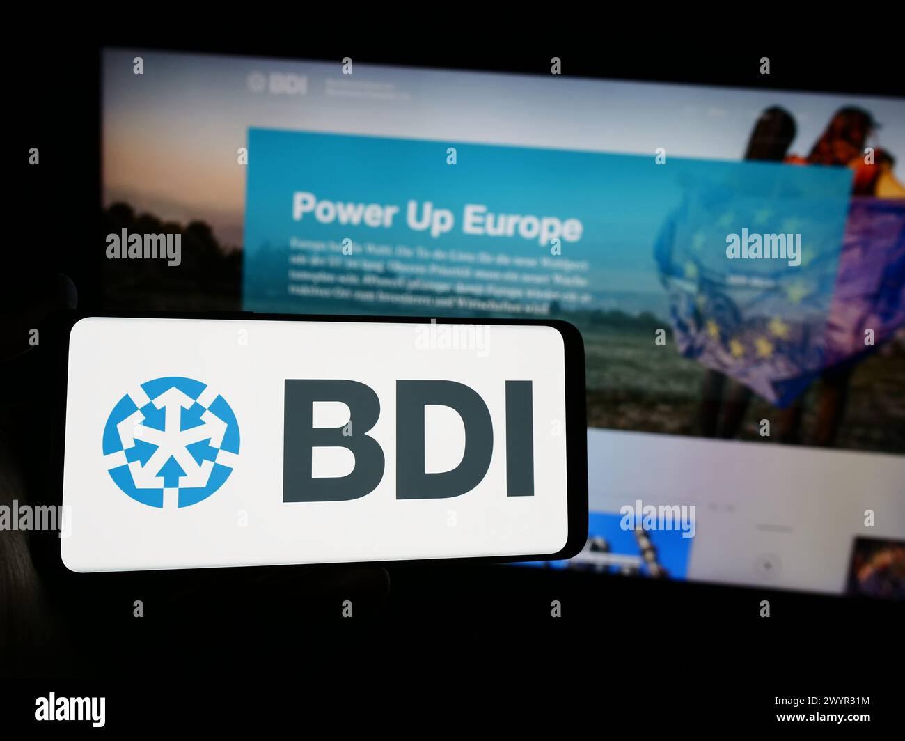 Persona che possiede uno smartphone con il logo della Bundesverband der Deutschen industrie e.V. (BDI) davanti al sito Web. Mettere a fuoco il display del telefono. Foto Stock