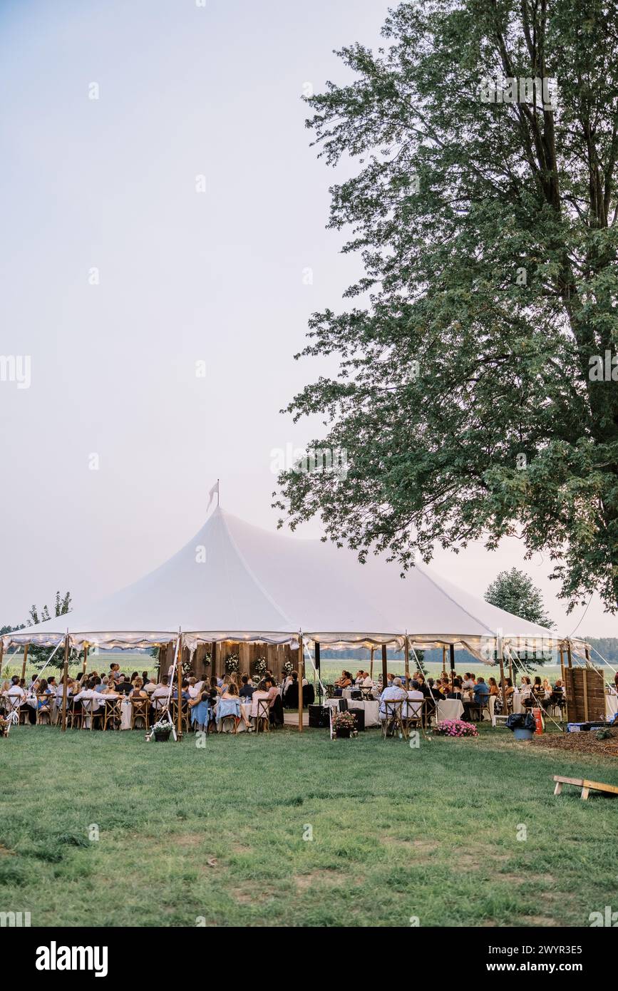 Eleganza al crepuscolo in una tenda per matrimoni in campagna Foto Stock