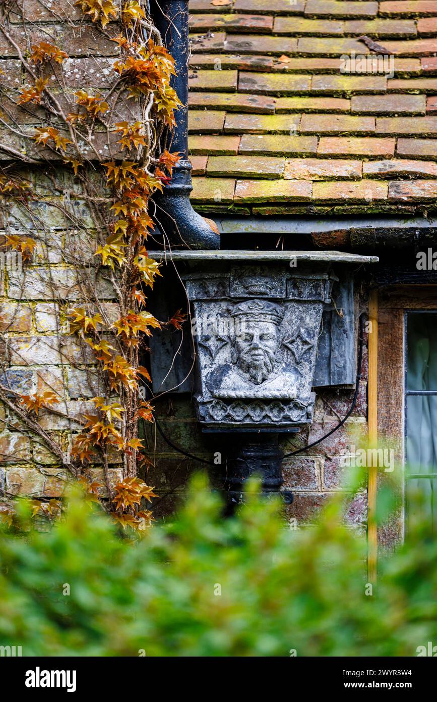Una tramoggia di metallo vintage con il ritratto di un re incoronato nel sistema grondaiante di Vann House vicino Hambledon, Surrey all'inizio della primavera Foto Stock