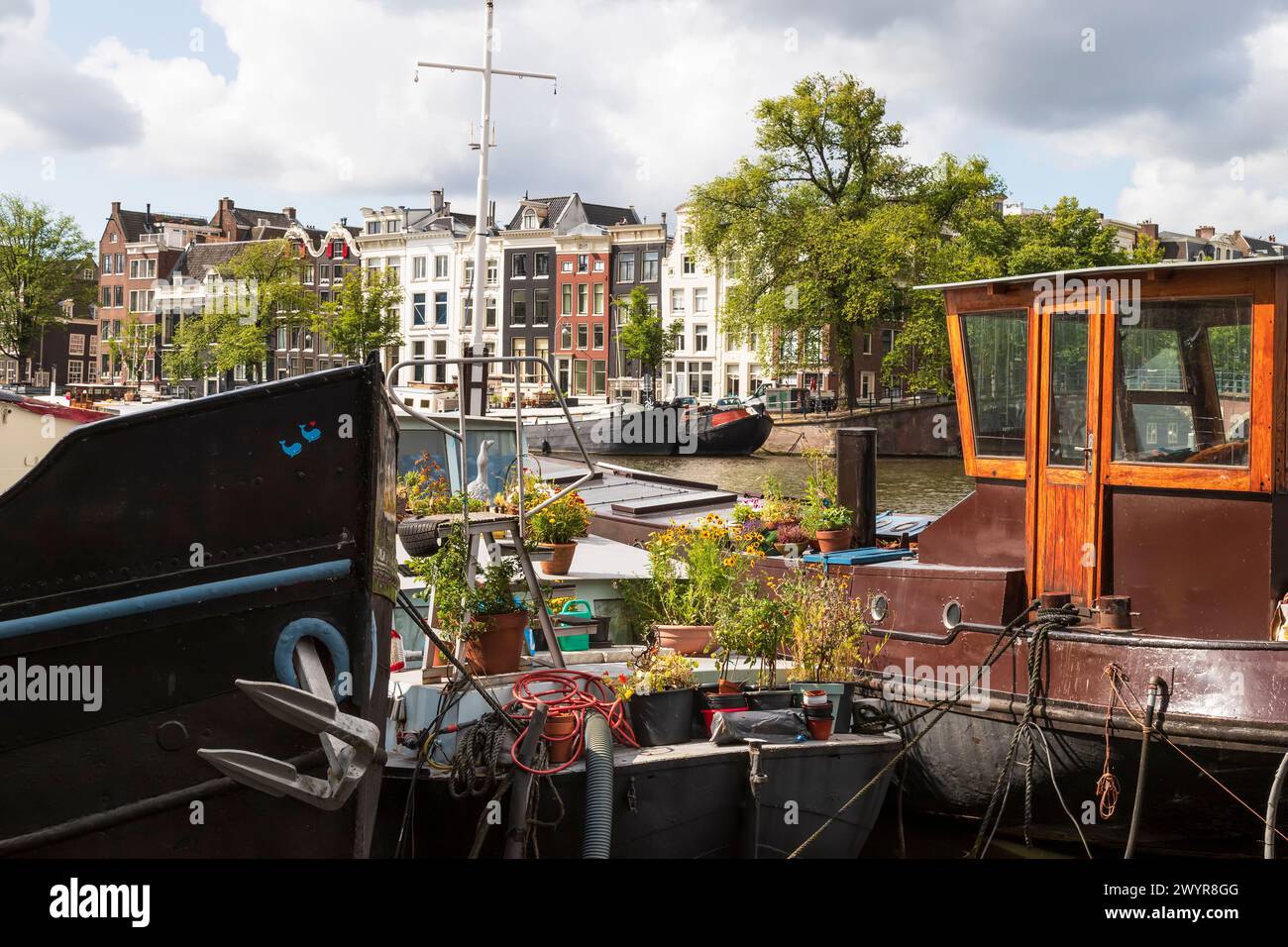Case galleggianti e case sui canali lungo il fiume Amstel ad Amsterdam. Foto Stock