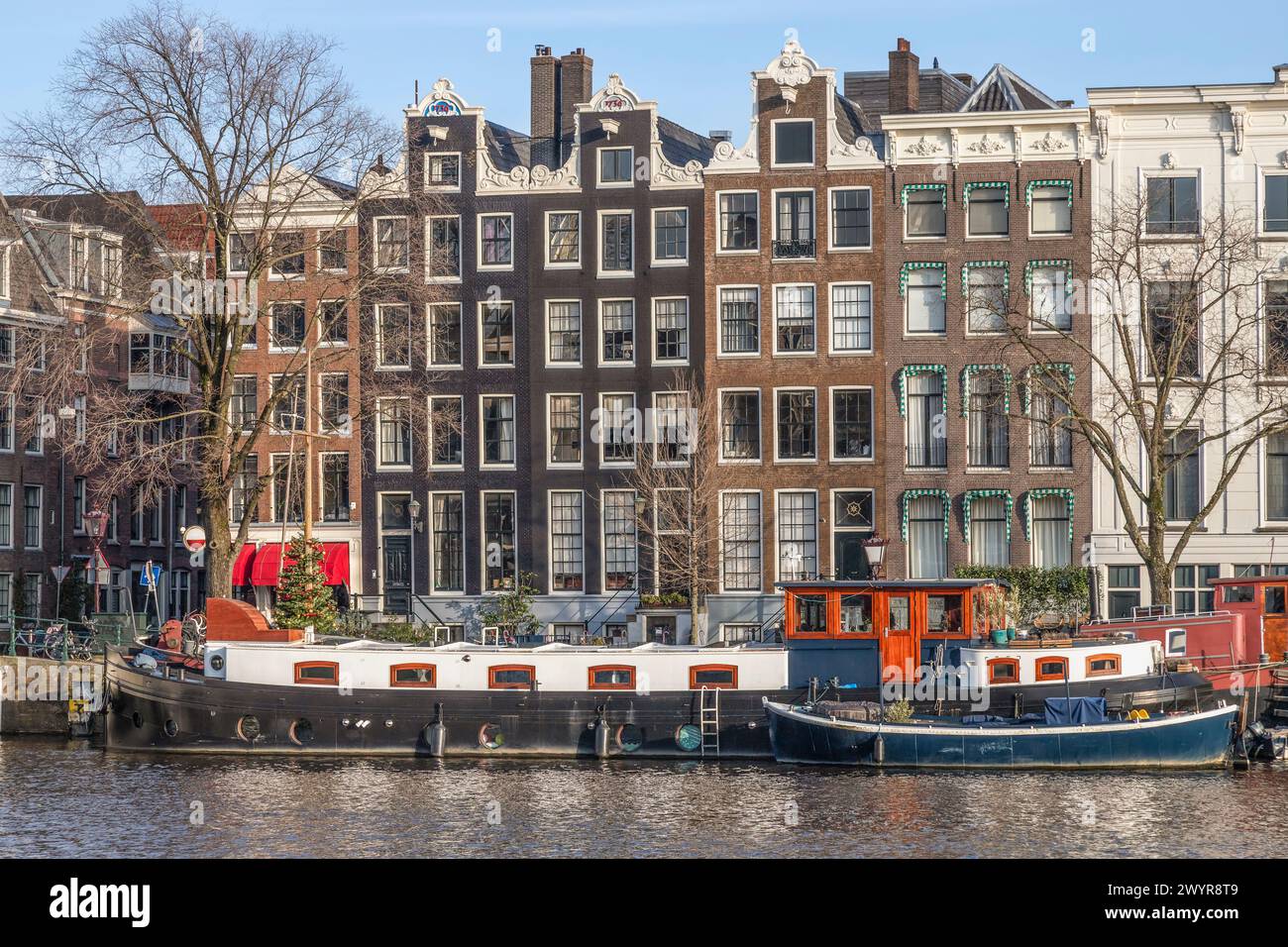 Storiche case sui canali lungo il fiume Amstel nel centro di Amsterdam. Foto Stock