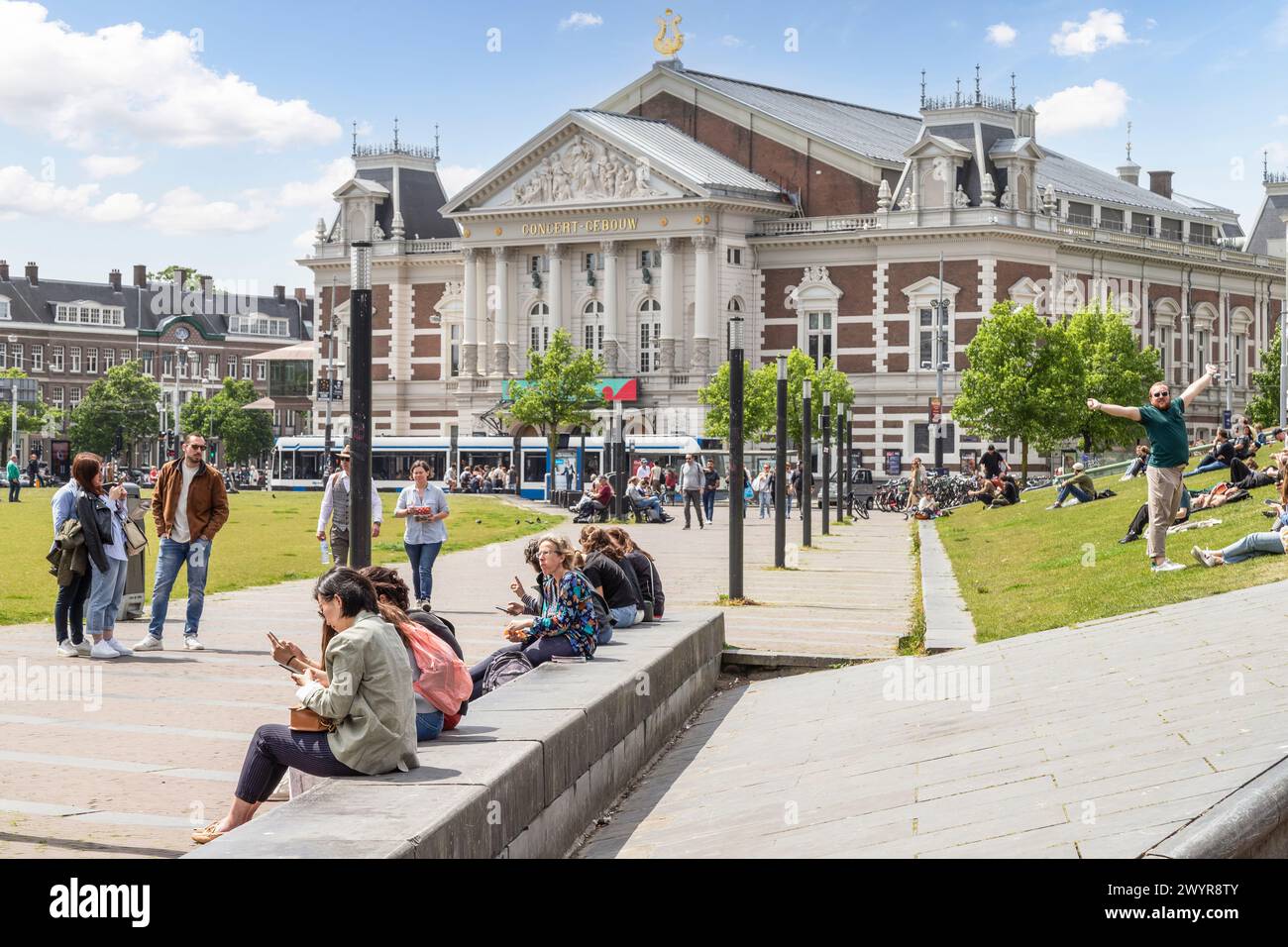 Le persone si divertono sul prato del Museumplein di fronte al Royal Concertgebouw di Amsterdam. Foto Stock