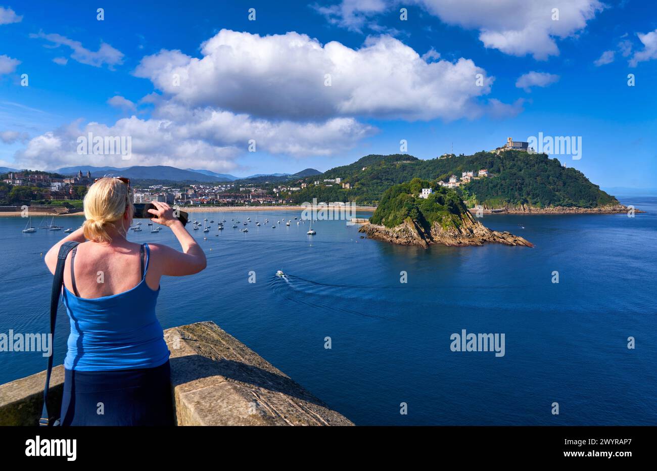 Turista fotografiando la Bahia de la Concha desde la Batería de las Damas, la Isla Santa Clara y el Monte Igeldo, Donostia, San Sebastian, Ciudad cosmopolita de 187,000 habitantes, destaca por su gastronomía, playas urbanas y edificios inspirrados en la arquitectura parisina, Gipuzkoa, Paesi Baschi, Spagna, Europa. Foto Stock