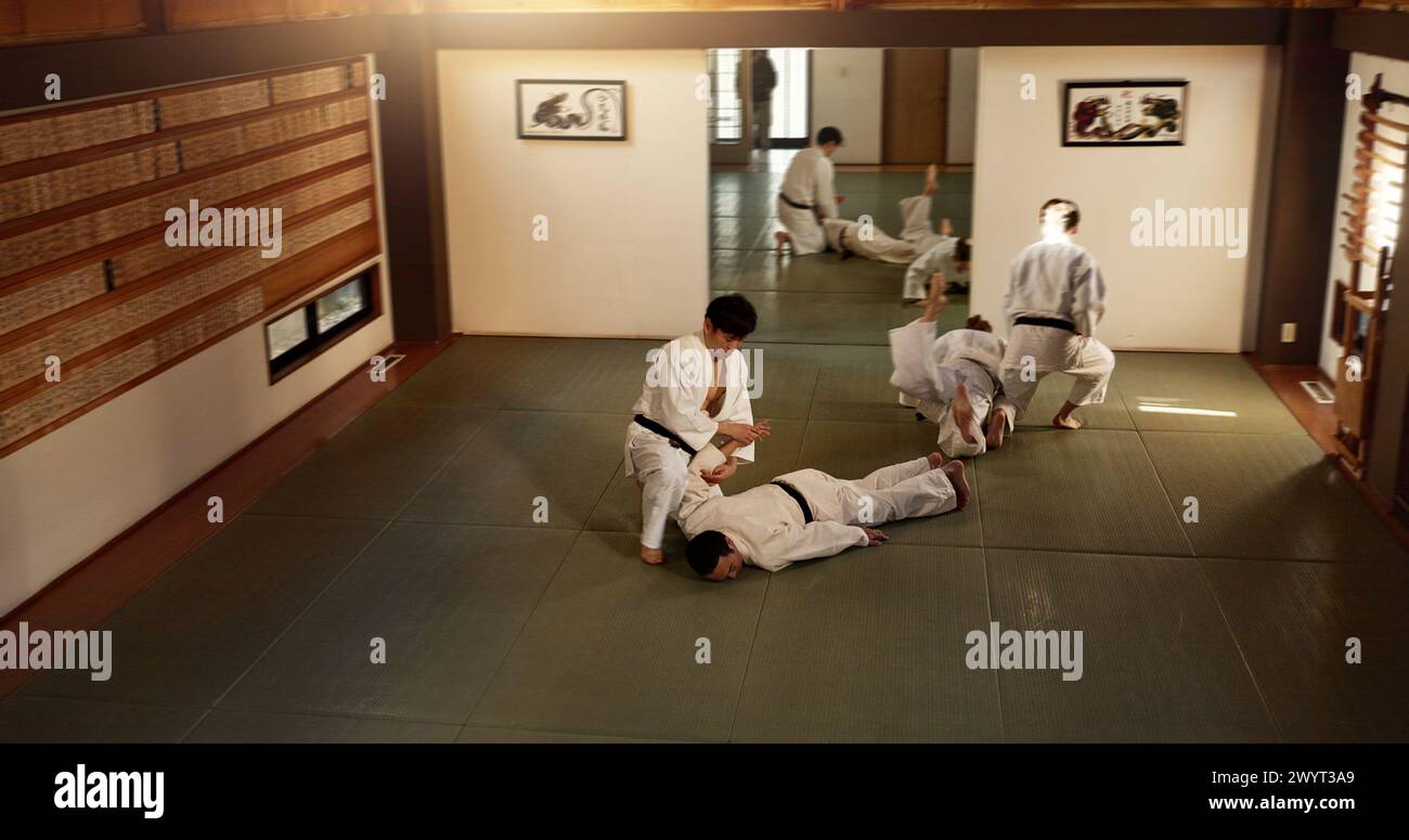 Uomini giapponesi, addestramento e combattimento aikido, arti marziali moderne e apprendimento autodifesa. Rispetto, studenti della cintura nera e istruzione nel dojo Place Foto Stock