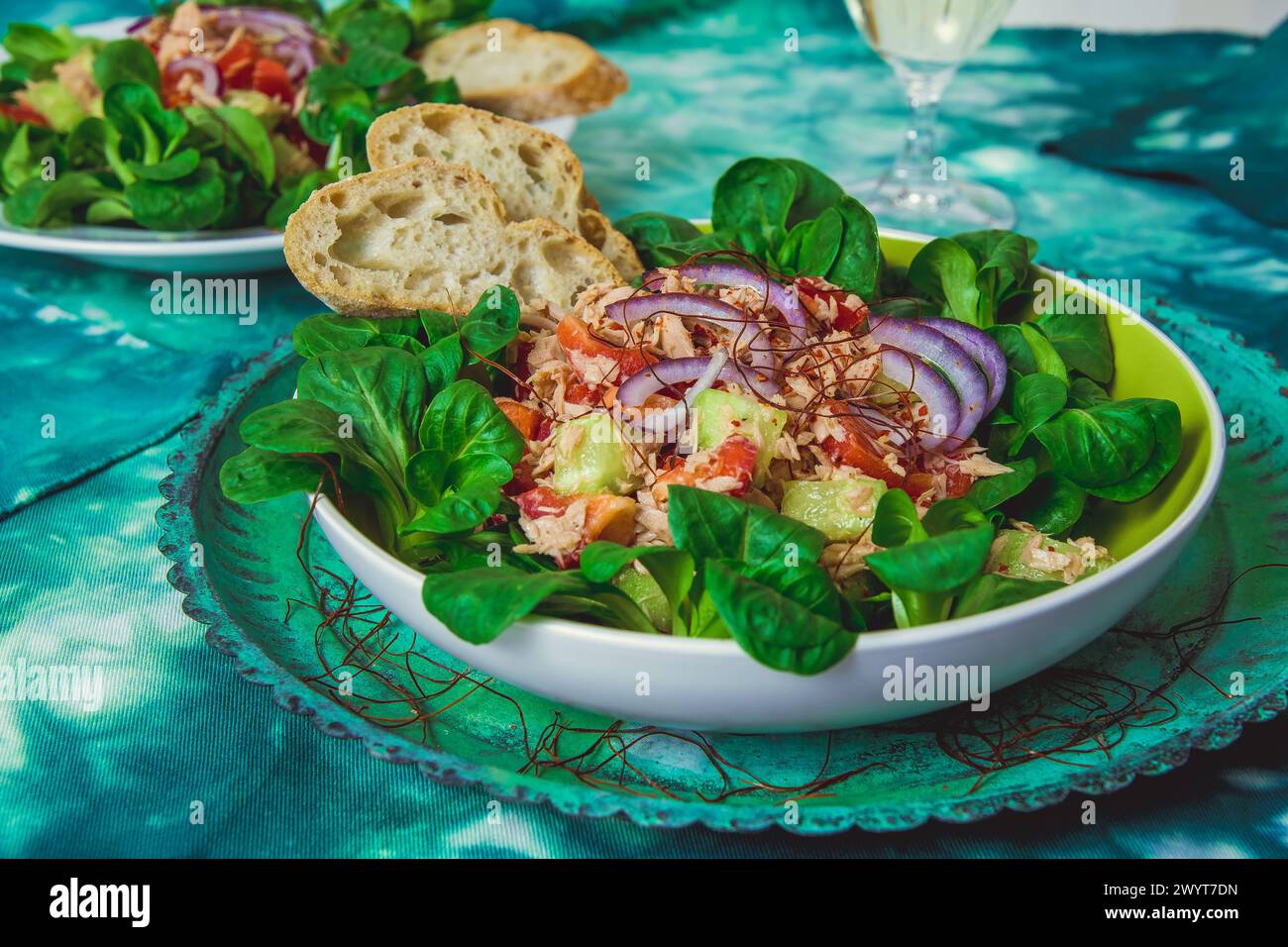 Insalata di tonno con peperone, cetriolo, cipolla e lattuga su tovaglia verde con motivo batik Foto Stock