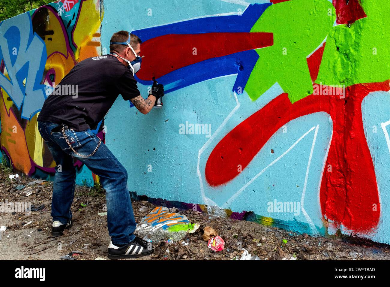 Graffity Artist Creating Graffity Artist Creating Jet un altro pezzo di arte urbana su parti dell'ex muro di Berlino, al confine con l'ex Germania Est o. Foto Stock