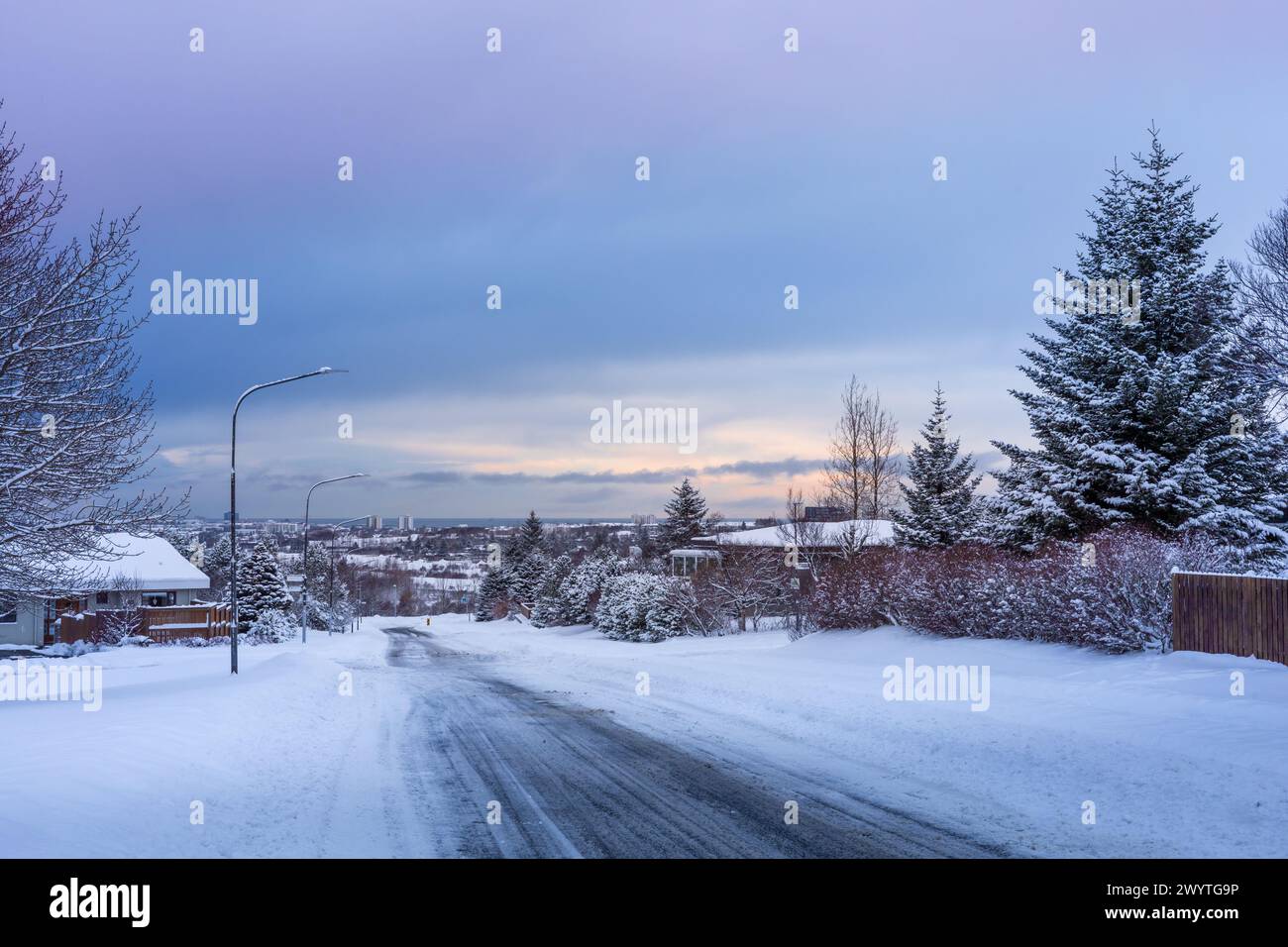 Reykjavik, Islanda - 15 gennaio 2024: Strade vuote e innevate nei sobborghi di Reykjavik in un buio giorno invernale. Foto Stock