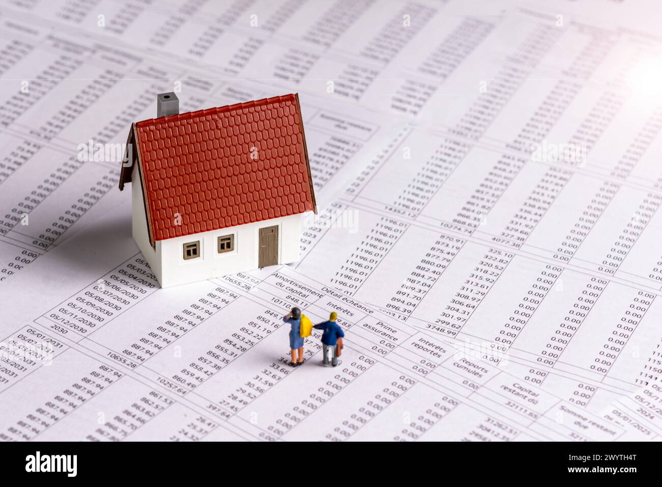 Due figurine e una casa modello su un documento di pianificazione del prestito immobiliare francese. Nozioni di pagamenti ipotecari, durata del credito e tassi di interesse Foto Stock