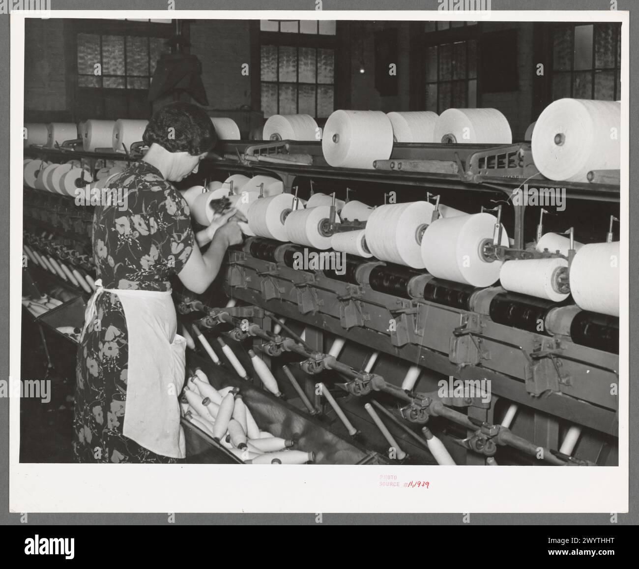 Il lavoratore avvolge il filo di cotone su bobine grandi. I cotonifici Laurel, Laurel, Mississippi Foto Stock