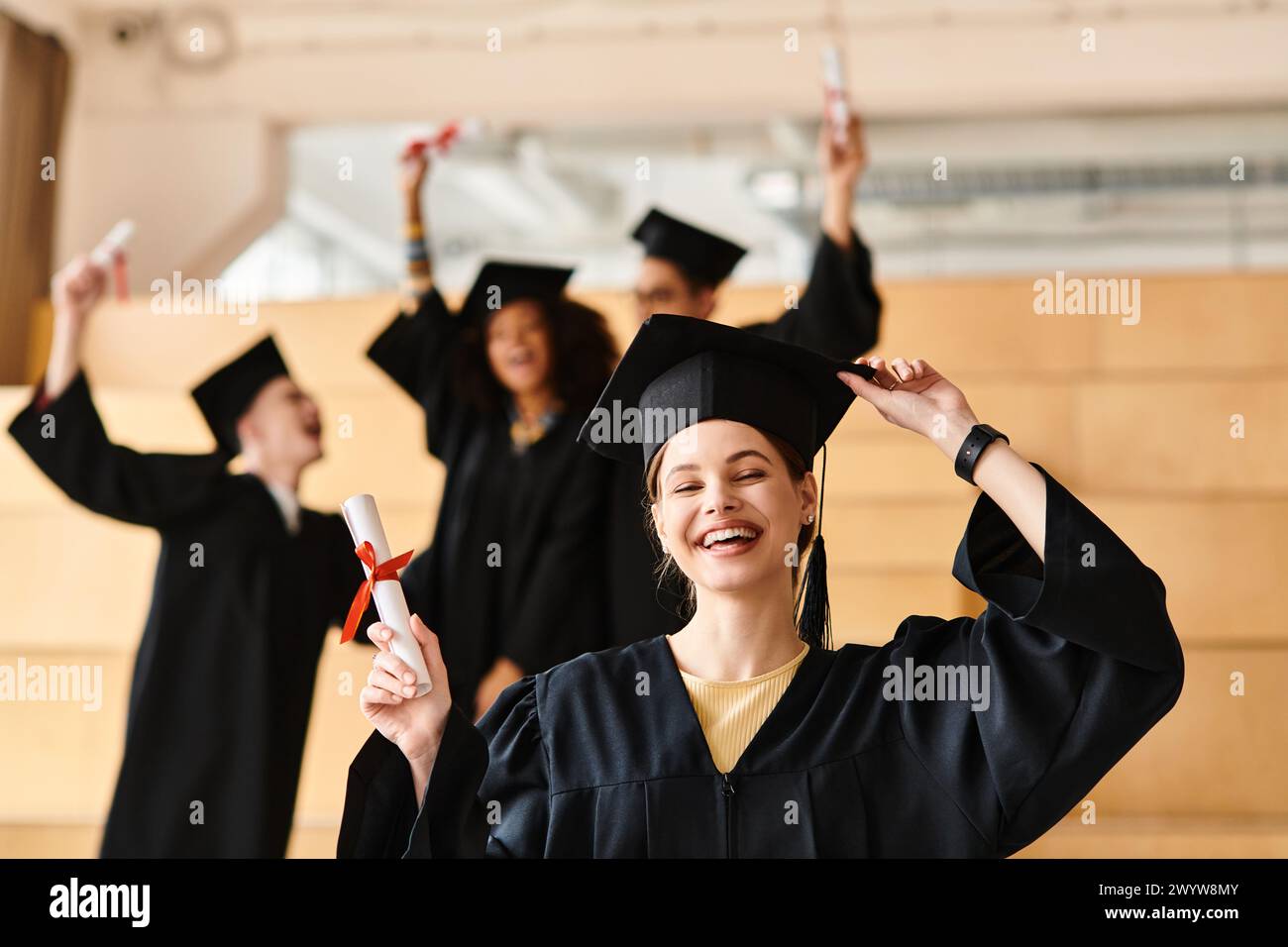 Un gruppo eterogeneo di studenti in abiti da laurea e mortai che celebrano il loro successo accademico. Foto Stock