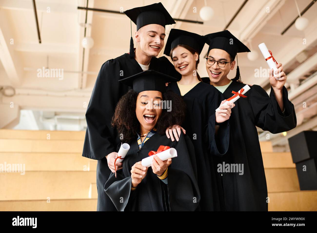 Un gruppo eterogeneo di studenti, tra cui individui caucasici, asiatici e afroamericani, che si uniscono in abiti e cappelli da laurea. Foto Stock