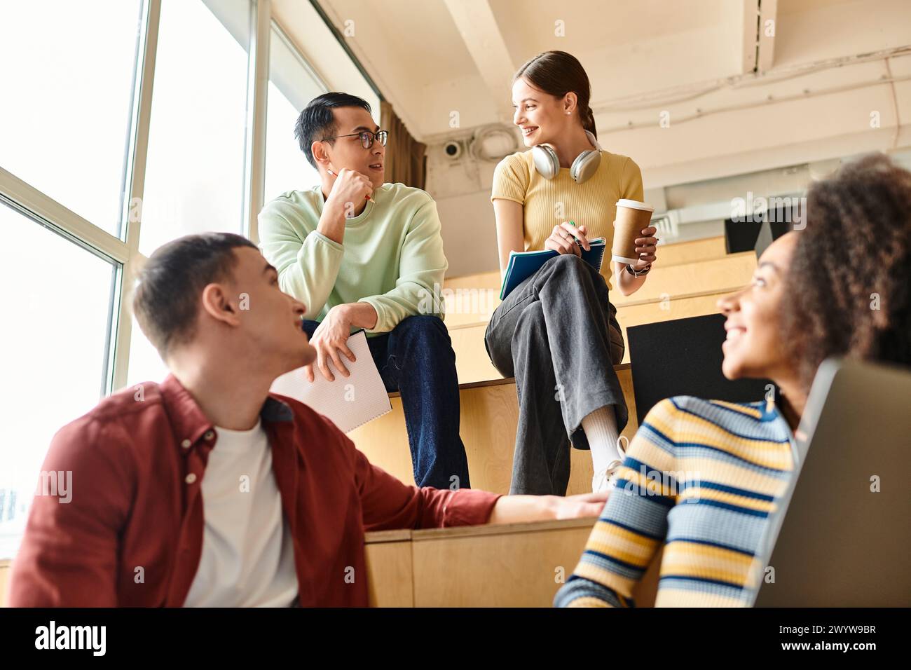 Studenti multiculturali profondamente coinvolti in una discussione, condividendo conoscenze ed esperienze in un ambiente educativo Foto Stock