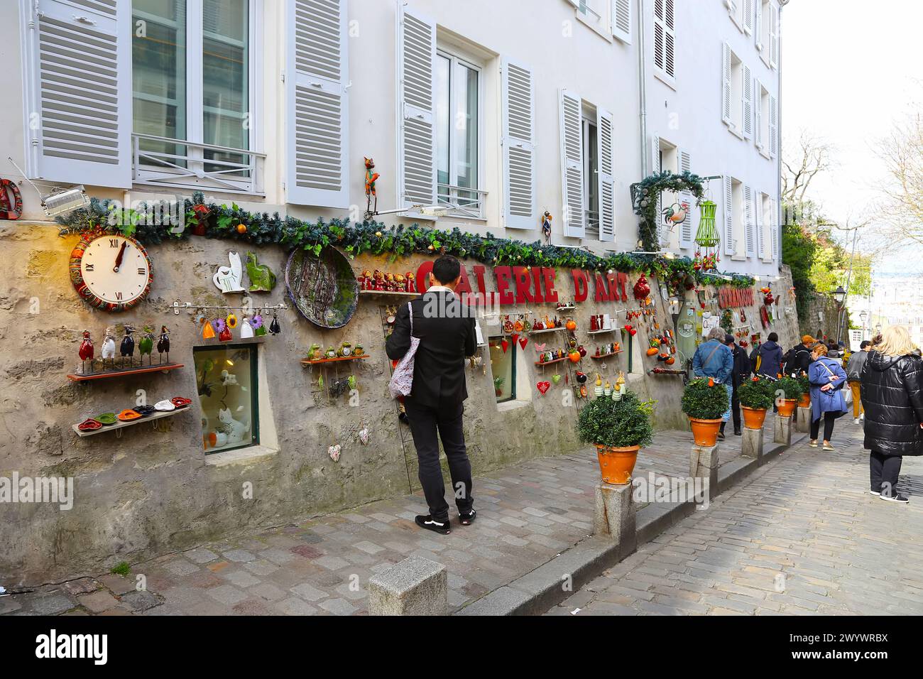 Parigi, Francia - 31 marzo 2024: Vista di un tipico caffè parigino, finestre con persiane blu, fiori, strade, gallerie con mostre, turisti e. Foto Stock