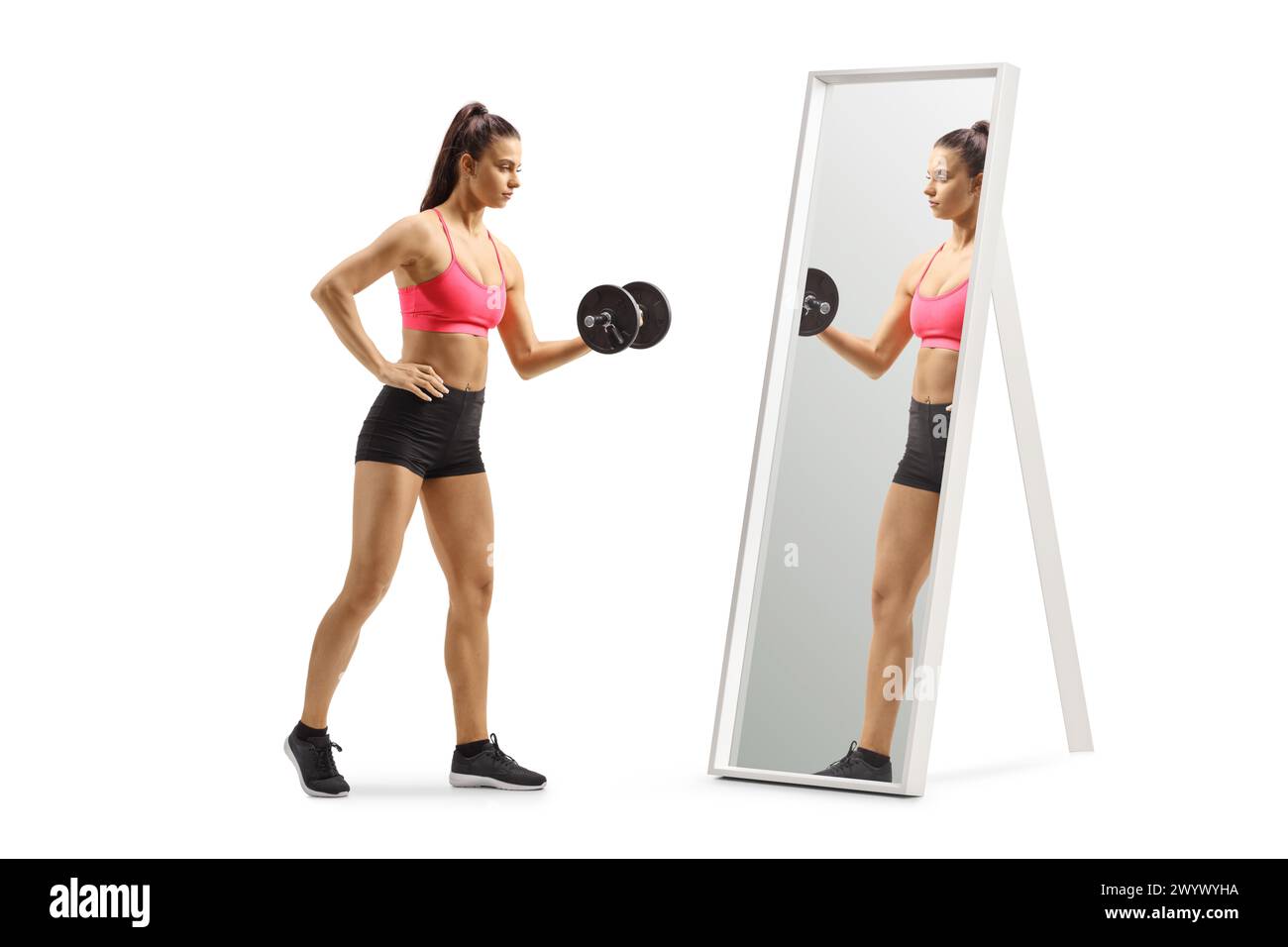 Donna che esercita l'allenamento con i pesi con un manubrio davanti a uno specchio isolato su sfondo bianco Foto Stock