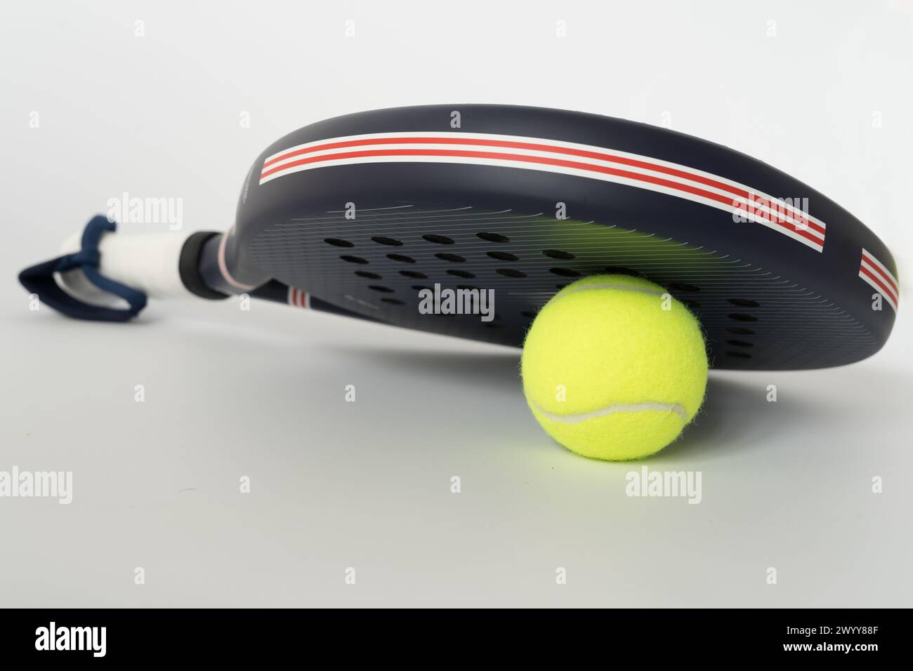 racchetta da paddle tennis professionale blu con palla gialla su sfondo bianco. copia spazio per il testo Foto Stock