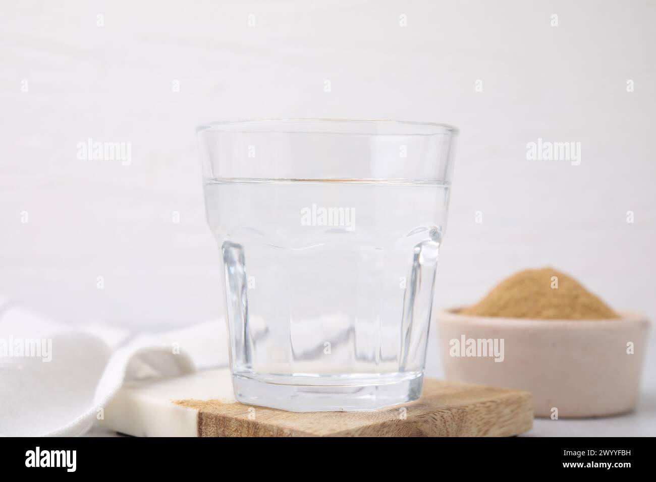 Fibra alimentare. Un bicchiere d'acqua e polvere di buccia di psico sulla tavola Foto Stock