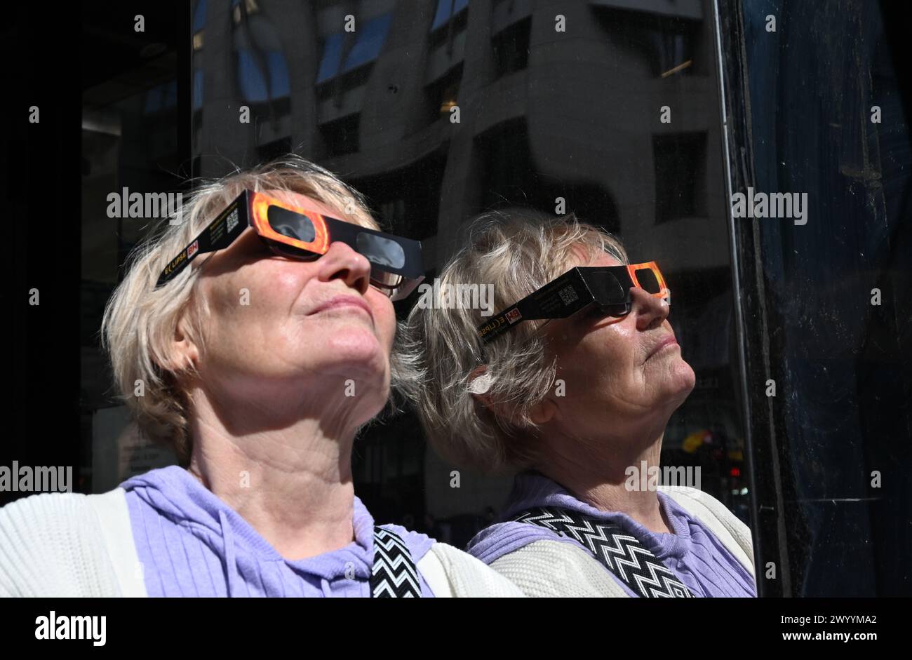 New York, New York, Stati Uniti. 8 aprile 2024. I newyorkesi versano sulla Fifth Avenue per guardare l'eclissi. La gente doveva trovare le strette parti di luce del sole tra gli edifici di Manhattan per guardare la luna bloccare il sole. In alcune aree i marciapiedi erano sovraffollati. (Foto: Andrea RENAULT/Zuma Press) (Credit Image: © Andrea Renault/ZUMA Press Wire) SOLO PER USO EDITORIALE! Non per USO commerciale! Foto Stock