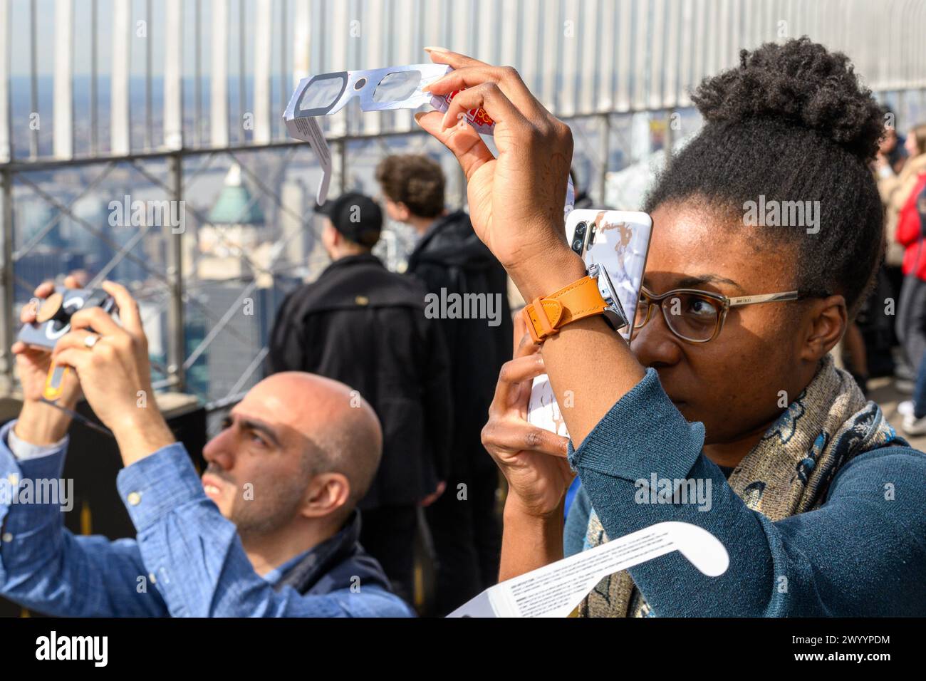 New York, Stati Uniti. 8 aprile 2024. La gente usa occhiali speciali sul suo telefono per fotografare un'eclissi solare dalla piattaforma di osservazione dell'Empire State Building. Crediti: Alamy Live News/Enrique Shore crediti: Enrique Shore/Alamy Live News Foto Stock