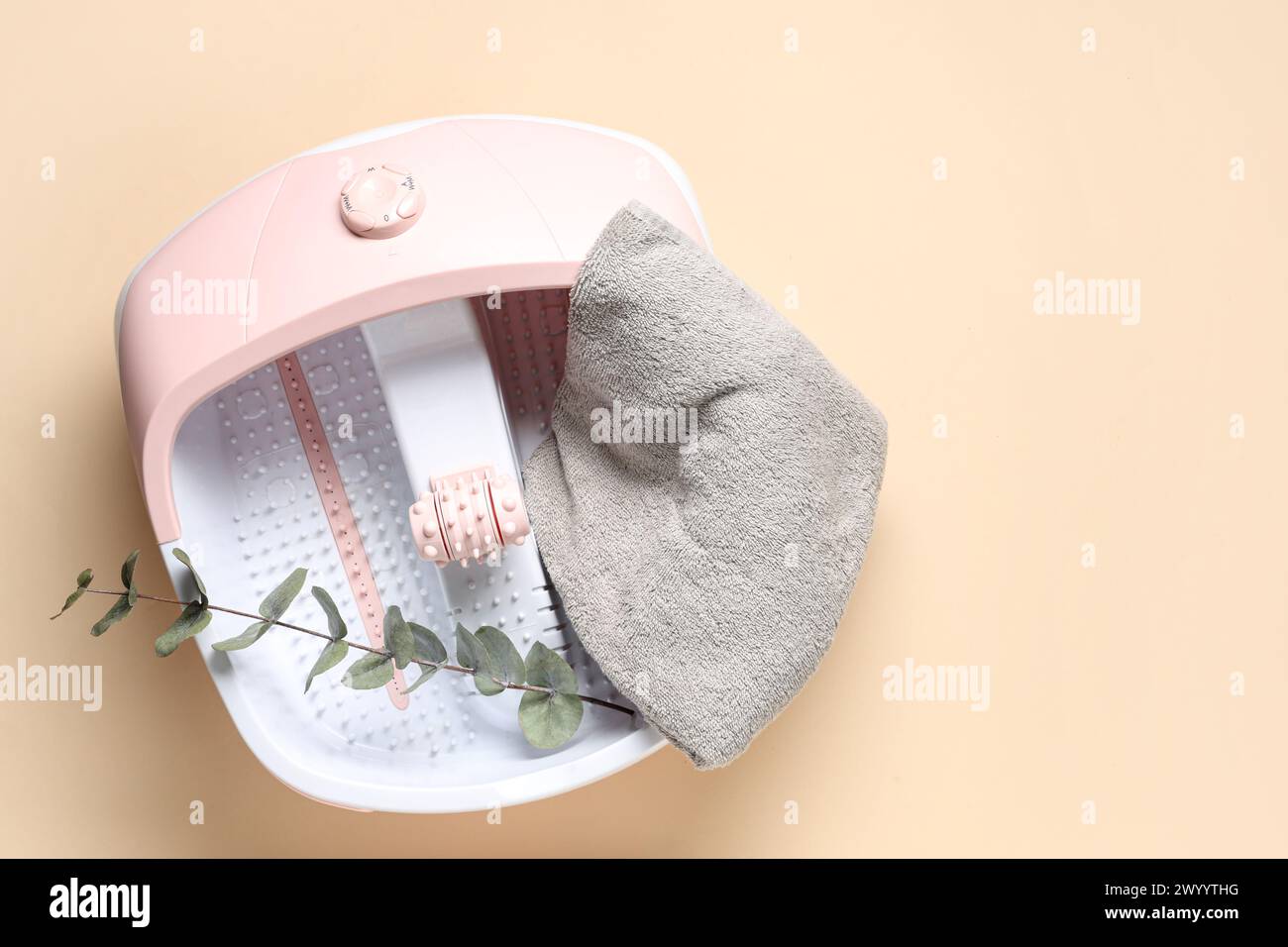 Massaggio ai piedi, asciugamano e foglie sullo sfondo beige Foto Stock