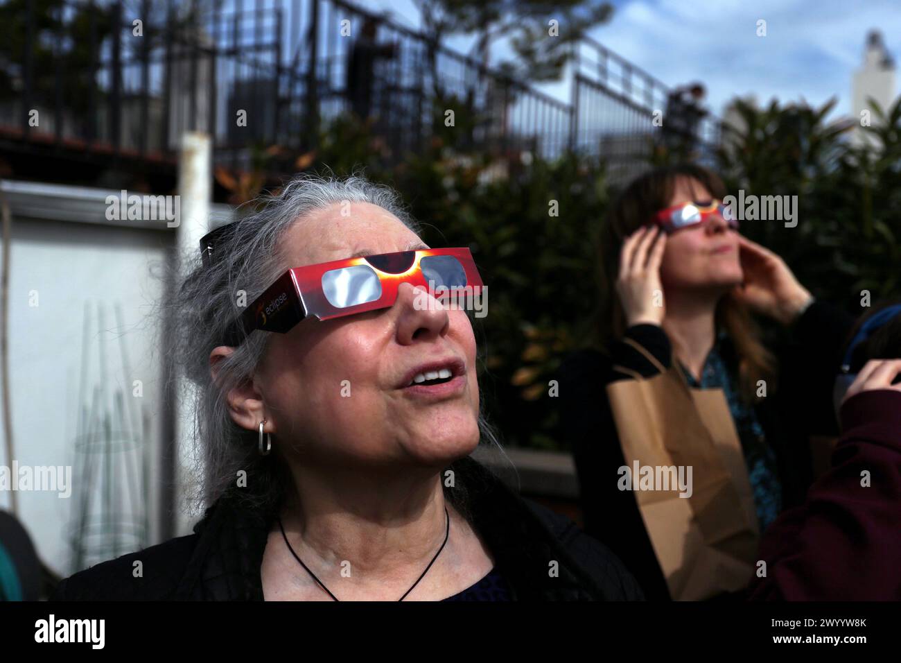 New York, New York, Stati Uniti. 8 aprile 2024. La gente sale su un tetto nella sezione Chelsea di Manhattan a New York per vedere l'eclissi solare che era visibile oggi sul Nord America e sul Canada. Crediti: Adam Stoltman/Alamy Live News Foto Stock