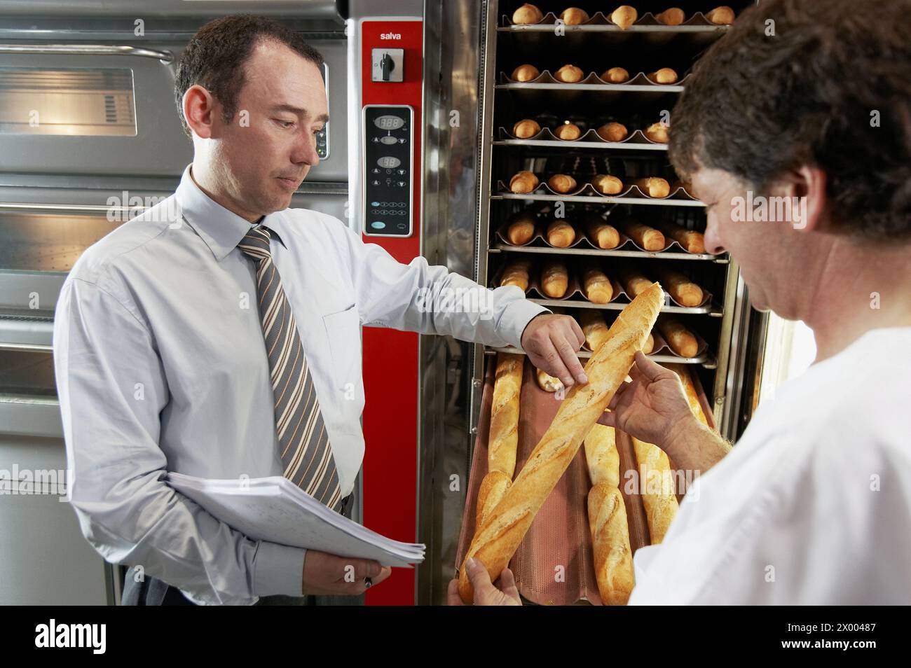 Tecnico e panettiere che controllano la qualità del pane e dei forni da forno. Foto Stock