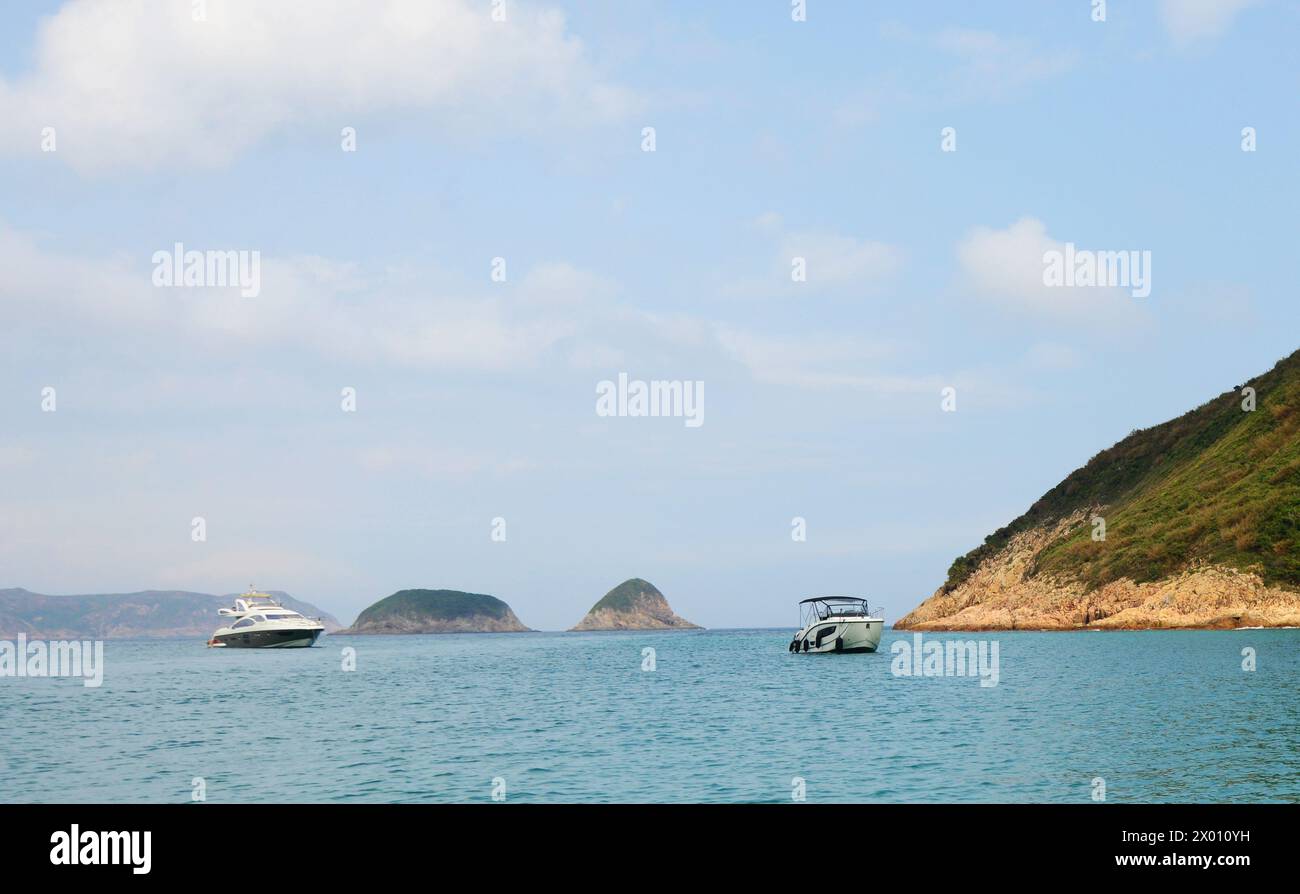 Una vista delle isole di Tsim Chau e Tai Chau al largo della costa della spiaggia di Sai Wan presso il parco di campagna di Sai Kung a Hong Kong. Foto Stock