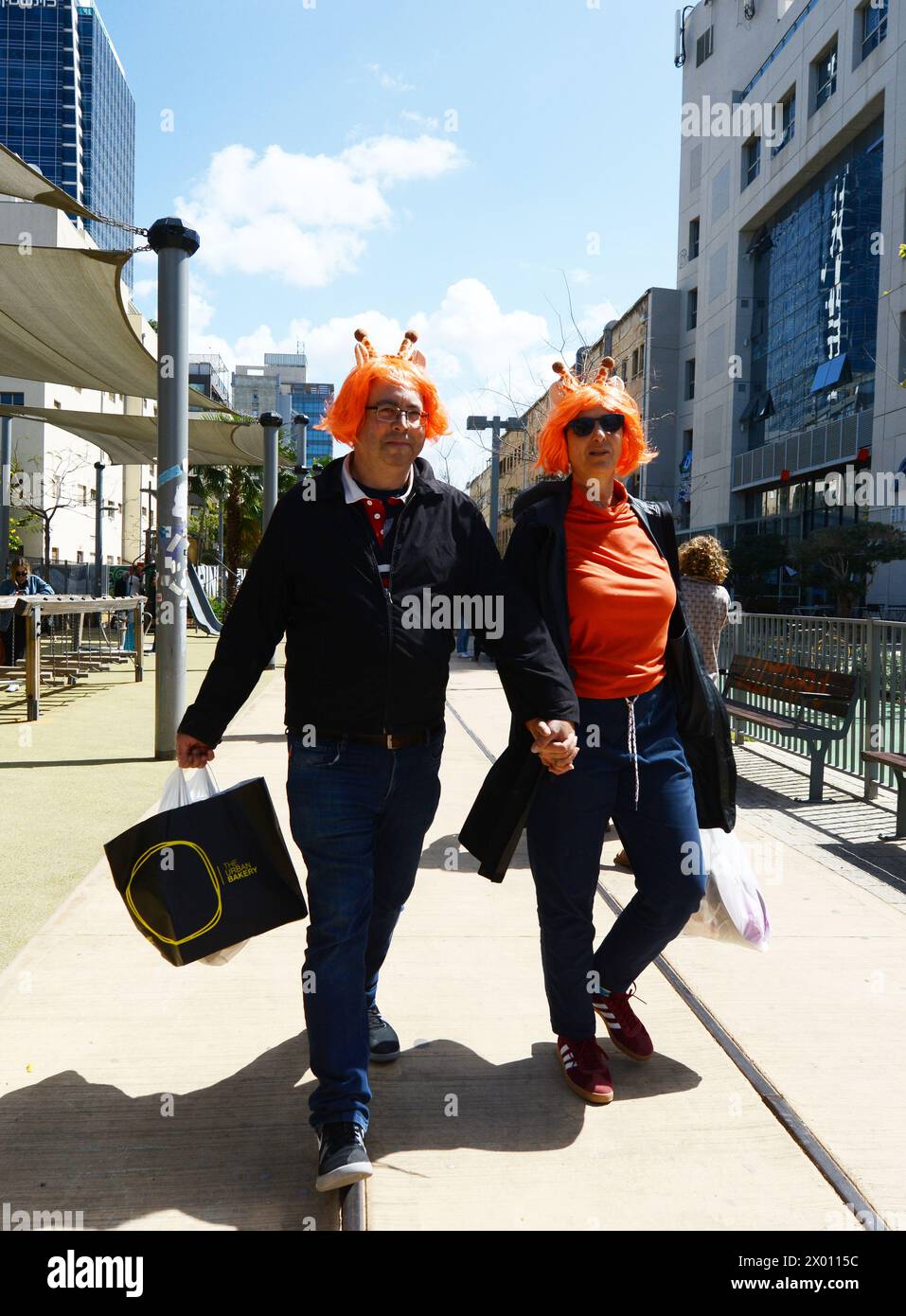 Una coppia israeliana che indossa parrucche arancioni per il Purim Festival. Tel-Aviv, Israele. Foto Stock