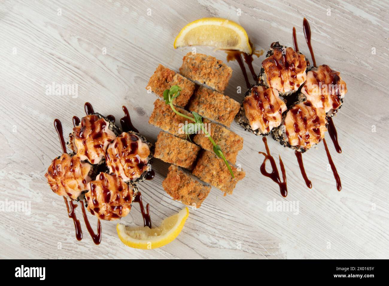 Set di vari panini di sushi su uno sfondo di legno bianco. Cibo giapponese. Foto Stock