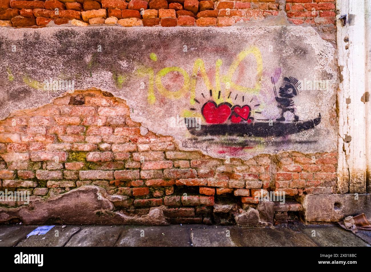 Un graffito con una gondola e cuori rossi su un muro di mattoni. Foto Stock