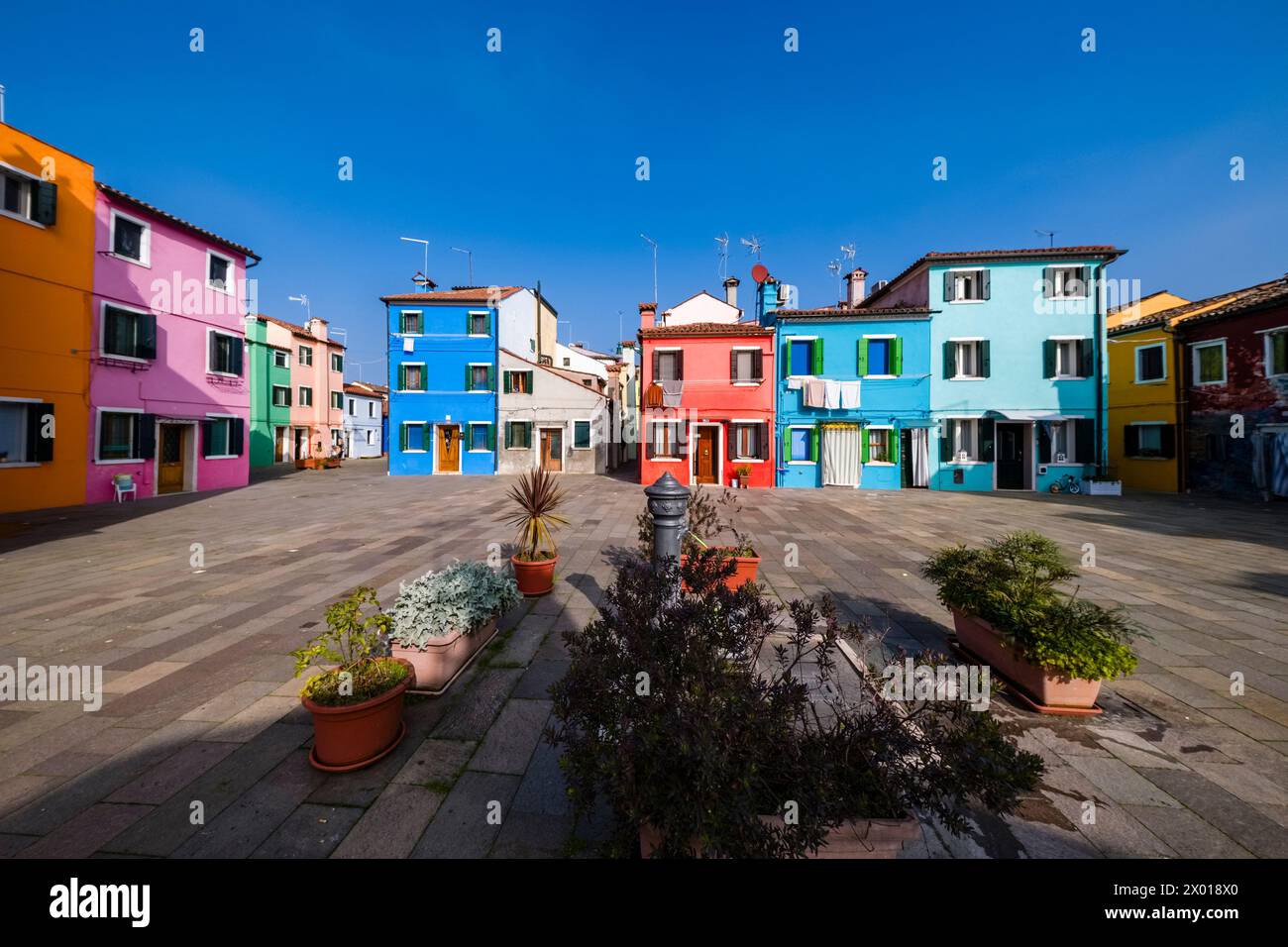 Case colorate, situate intorno ad una piccola piazza sull'isola di Burano. Foto Stock